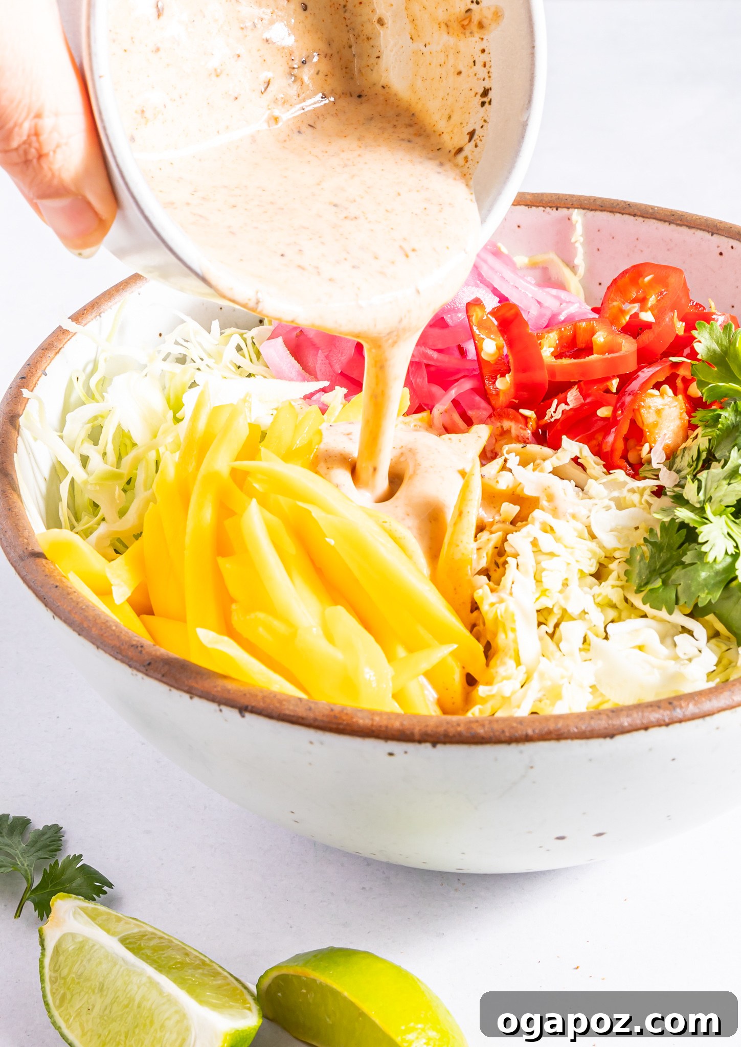 Easy Caribbean Coleslaw Recipe with the dressing drizzled over it, before final toss.