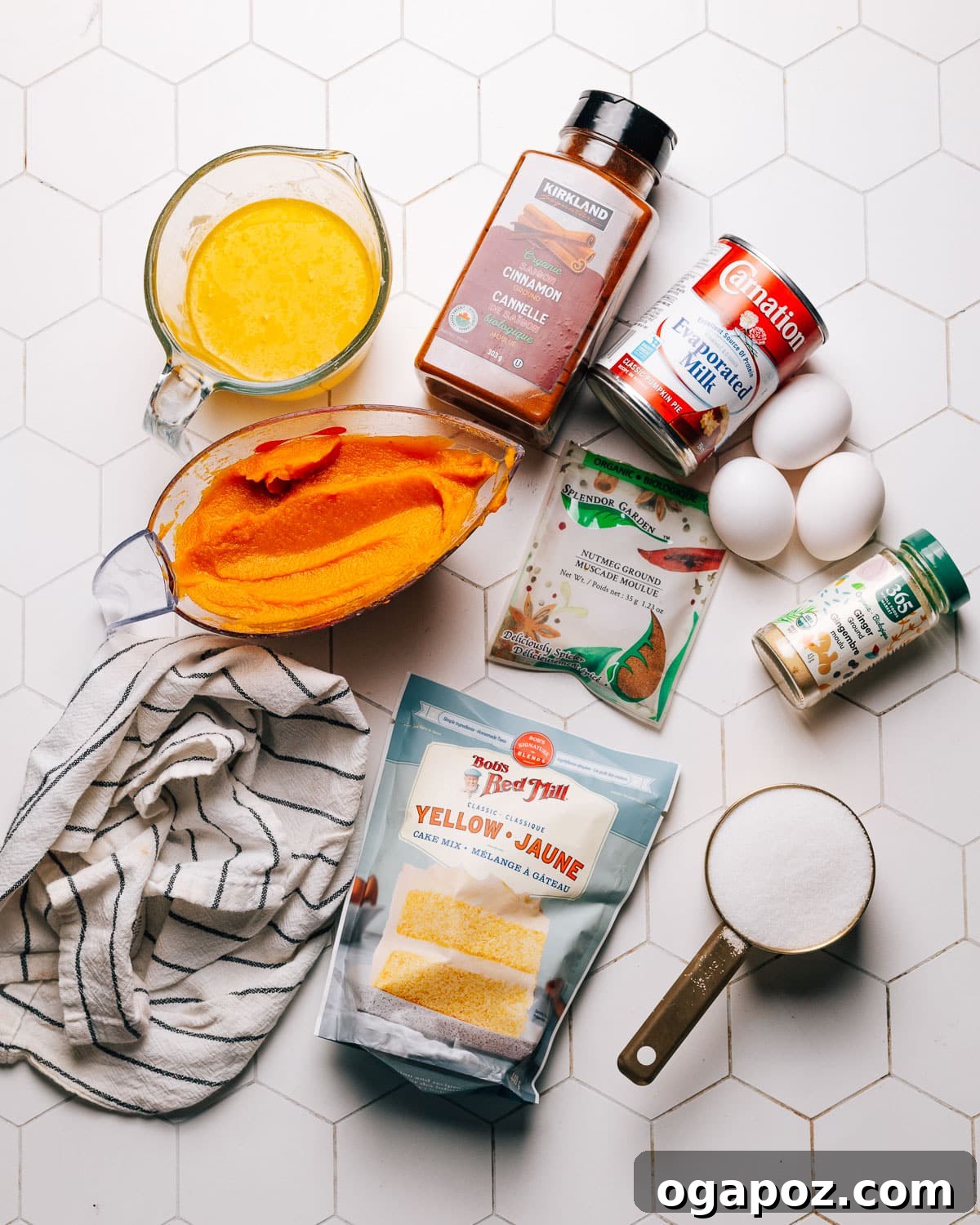 A flat lay photograph showcasing all the pantry-friendly ingredients needed for Pumpkin Dump Cake, including pumpkin puree, cake mix, and spices.