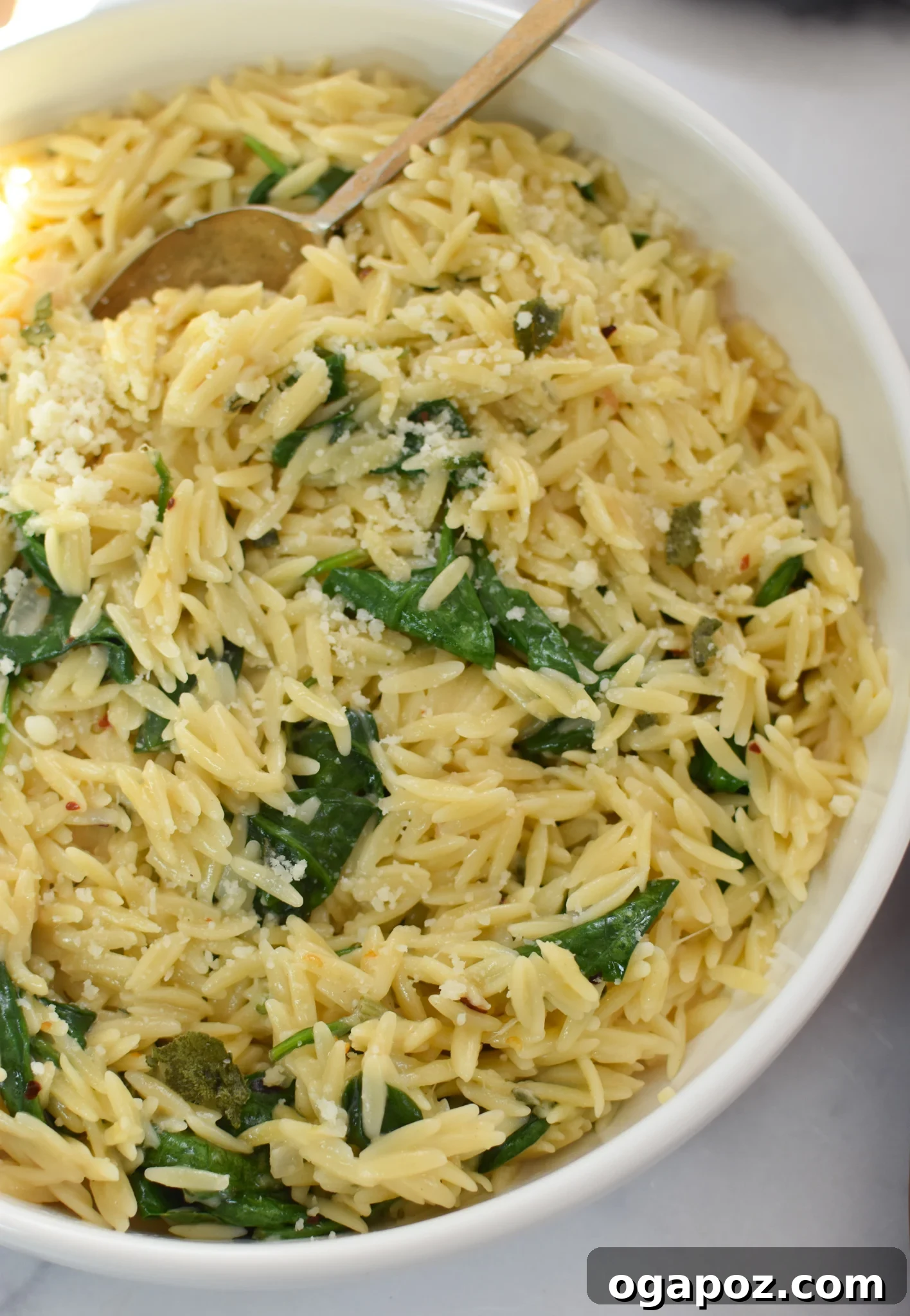 Creamy Parmesan orzo with spinach in a skillet, ready to be served.