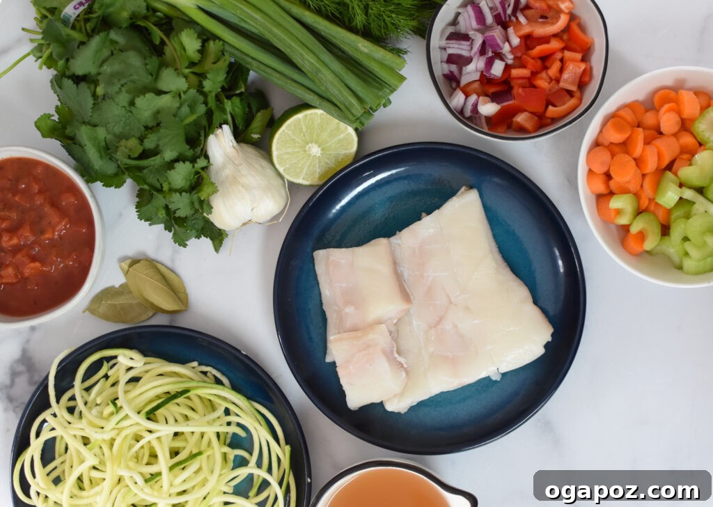 Rustic Mediterranean Fish Soup 3 Fresh ingredients laid out for Mediterranean Fish Soup including vegetables, spices, and halibut.