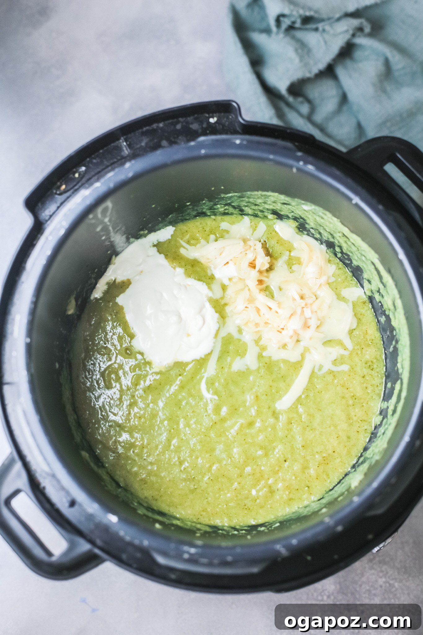 Velvety Instant Pot Broccoli Soup 8 A stream of heavy cream being poured into the blended Instant Pot Broccoli Soup, enhancing its rich and smooth texture.