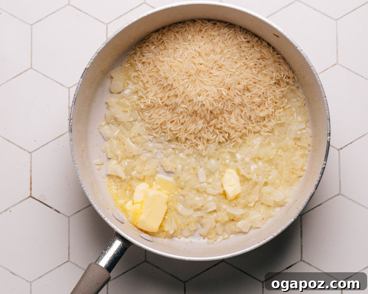 Effortless Chicken and Rice Delight 6 Step 3: Chopped onions and minced garlic are sautéing in the same skillet after the chicken has been removed, creating a flavor base.