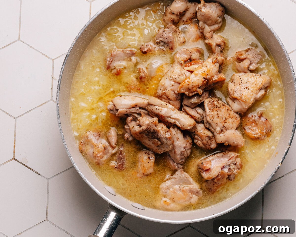 Effortless Chicken and Rice Delight 8 Step 5: Chicken broth is poured into the skillet with the toasted rice and aromatics, about to be brought to a boil.