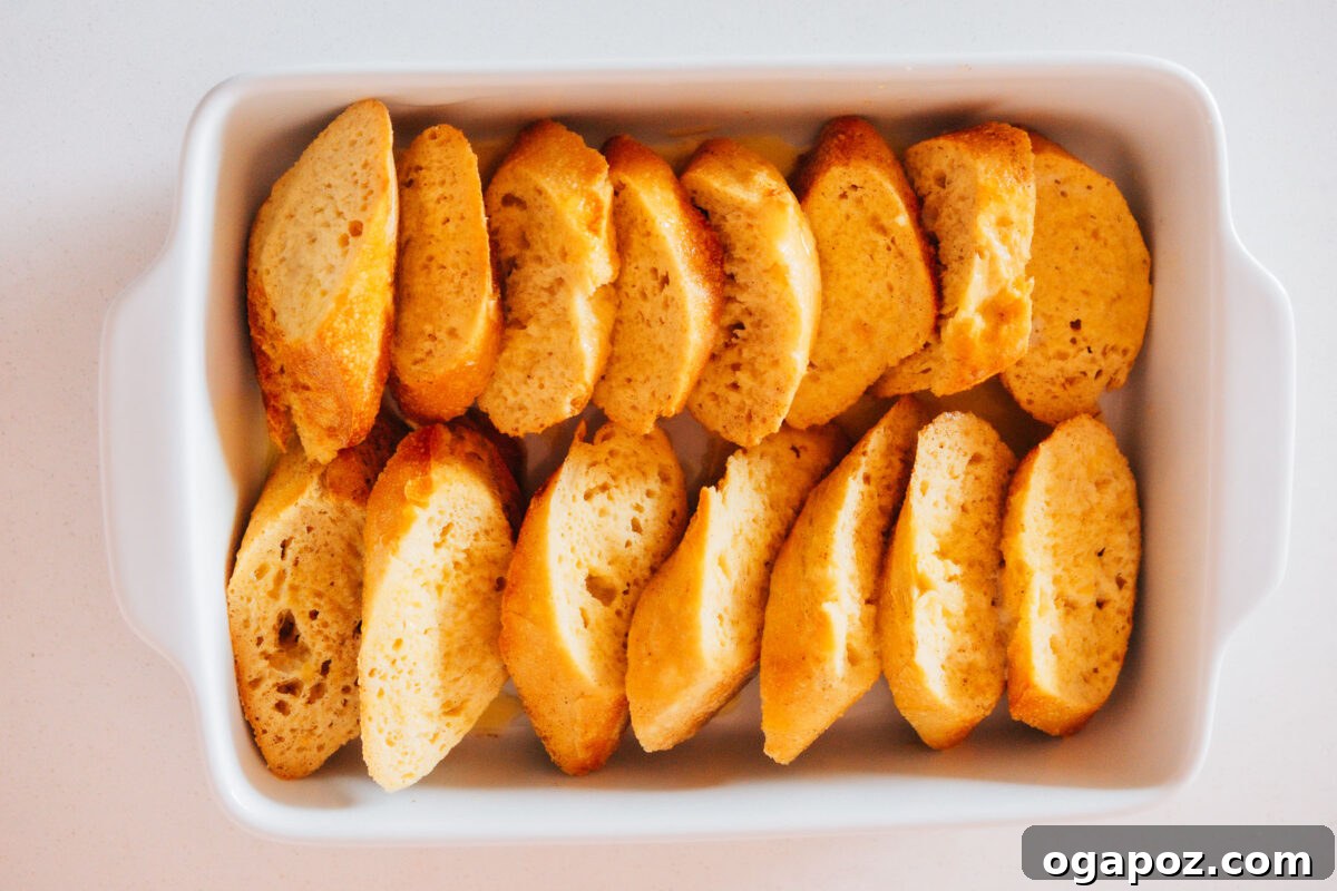 Sweet Morning French Toast Bake 5 Step 2: Layering the custard-soaked bread slices in a buttered baking dish for a French Toast Bake.