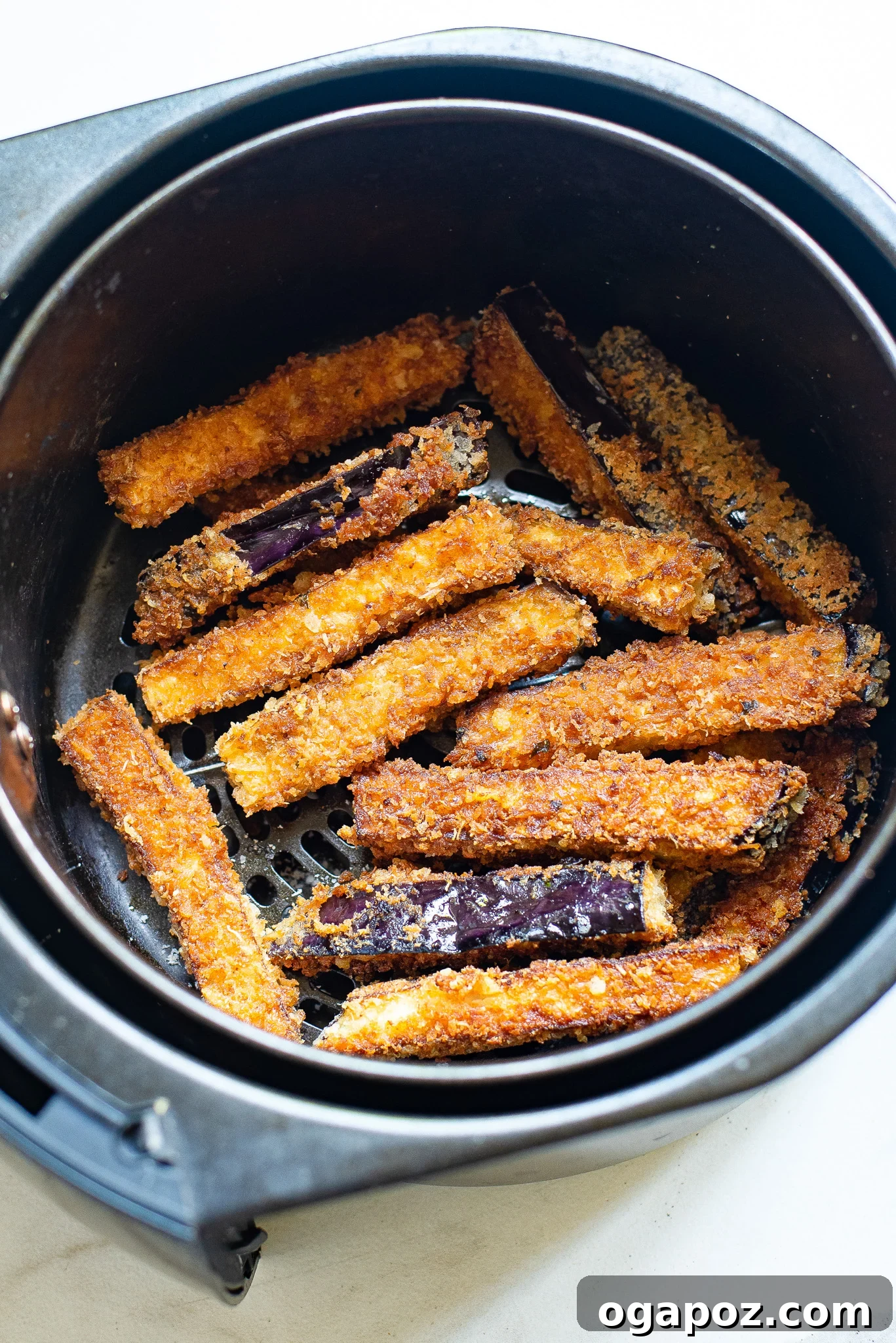 Irresistible Air Fryer Eggplant Fries 8 Perfectly golden and crispy Air Fryer Eggplant Fries in the air fryer basket, ready to be served.