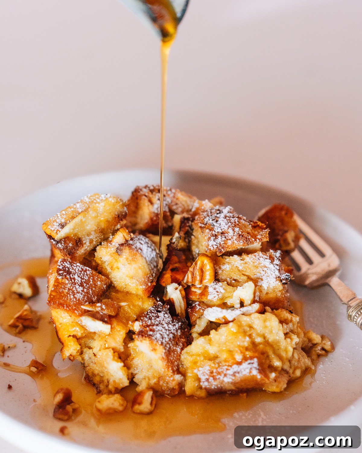 Easy Overnight French Toast Bake 2 Golden-brown French Toast Casserole topped with powdered sugar and berries, ready to be served.