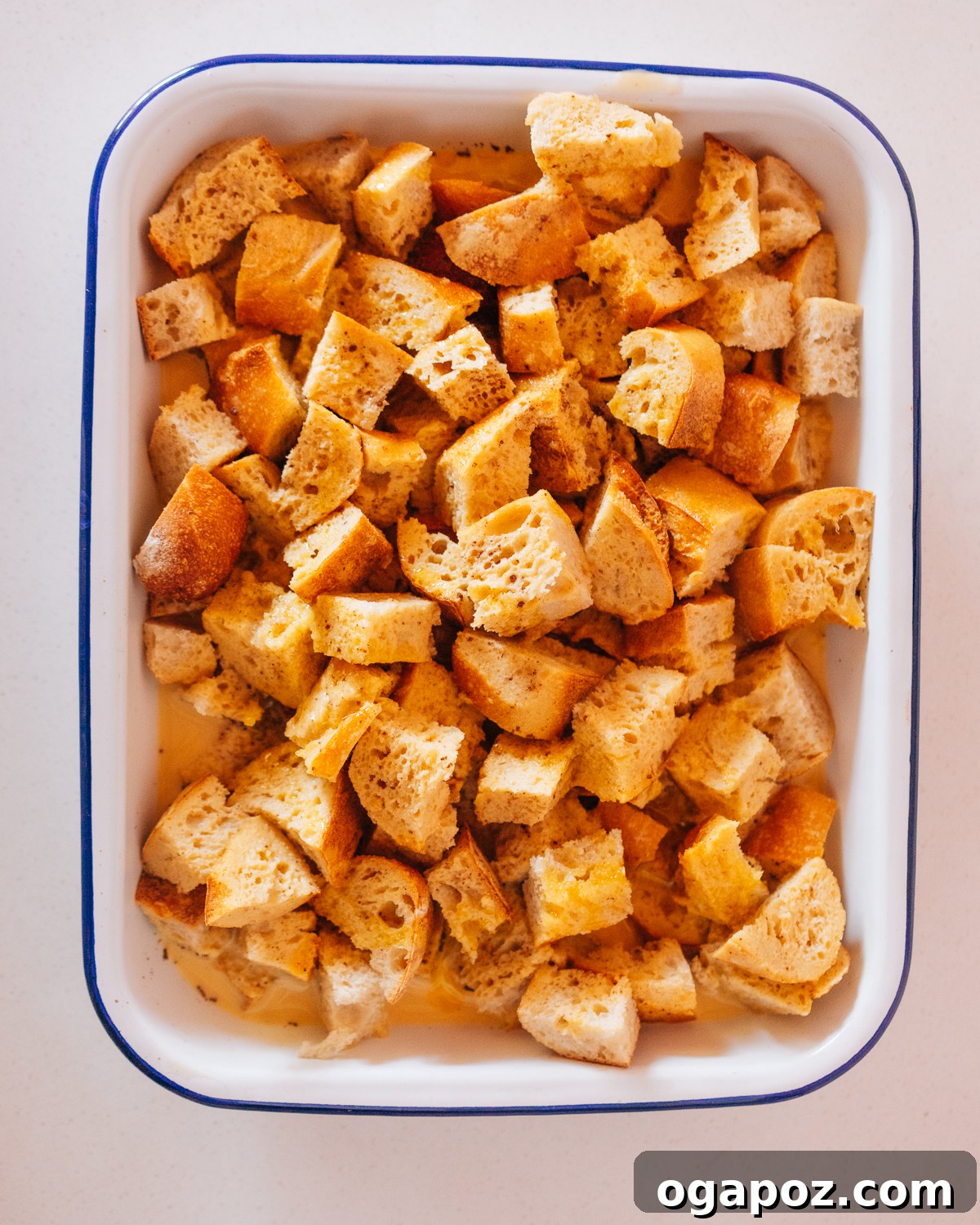 Easy Overnight French Toast Bake 5 Step 2: Hands whisking eggs, milk, cream, and other ingredients in a large bowl to form the custard.