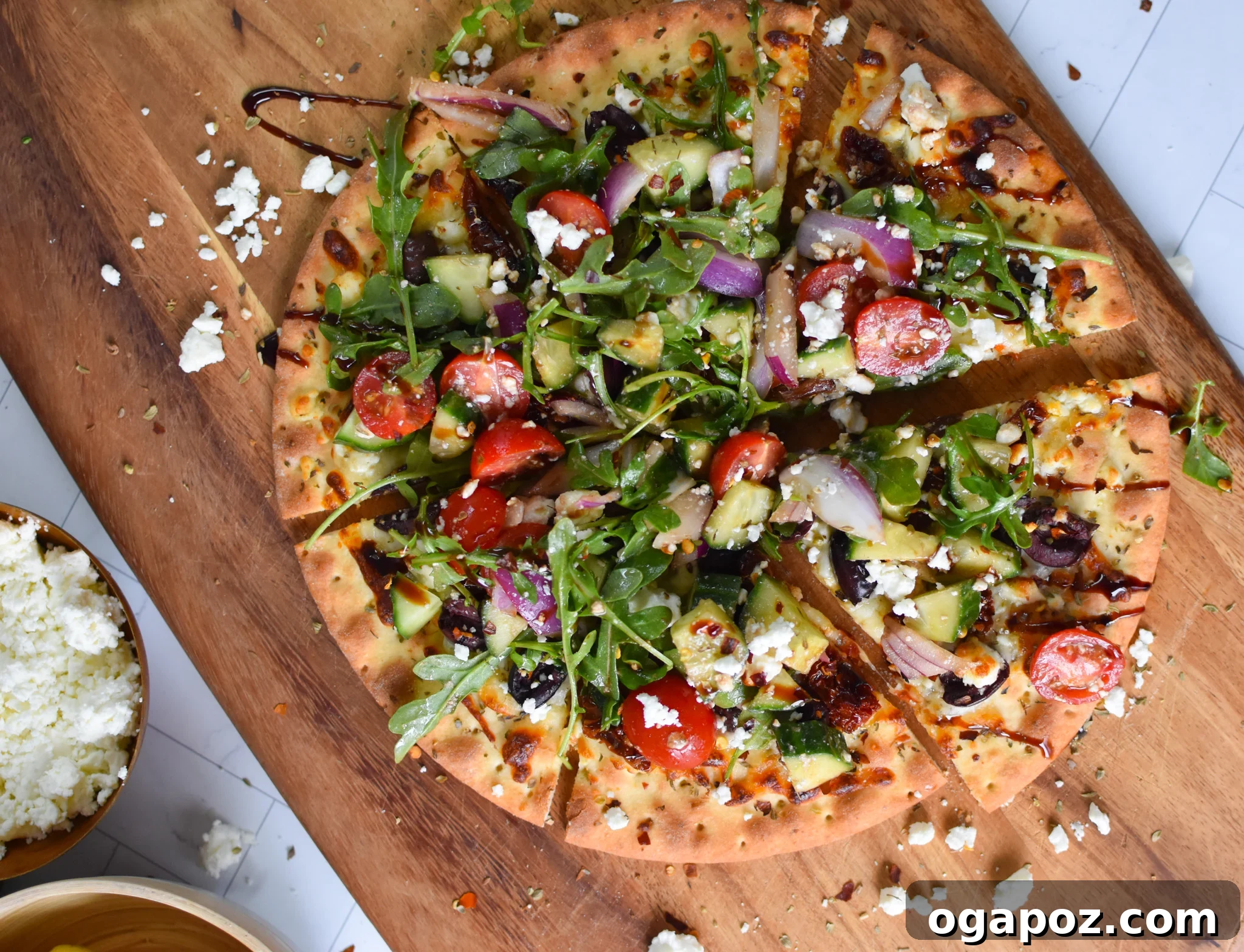 Aegean Delight Pizza 4 Freshly baked Greek Pizza on a wooden cutting board, ready to be topped.