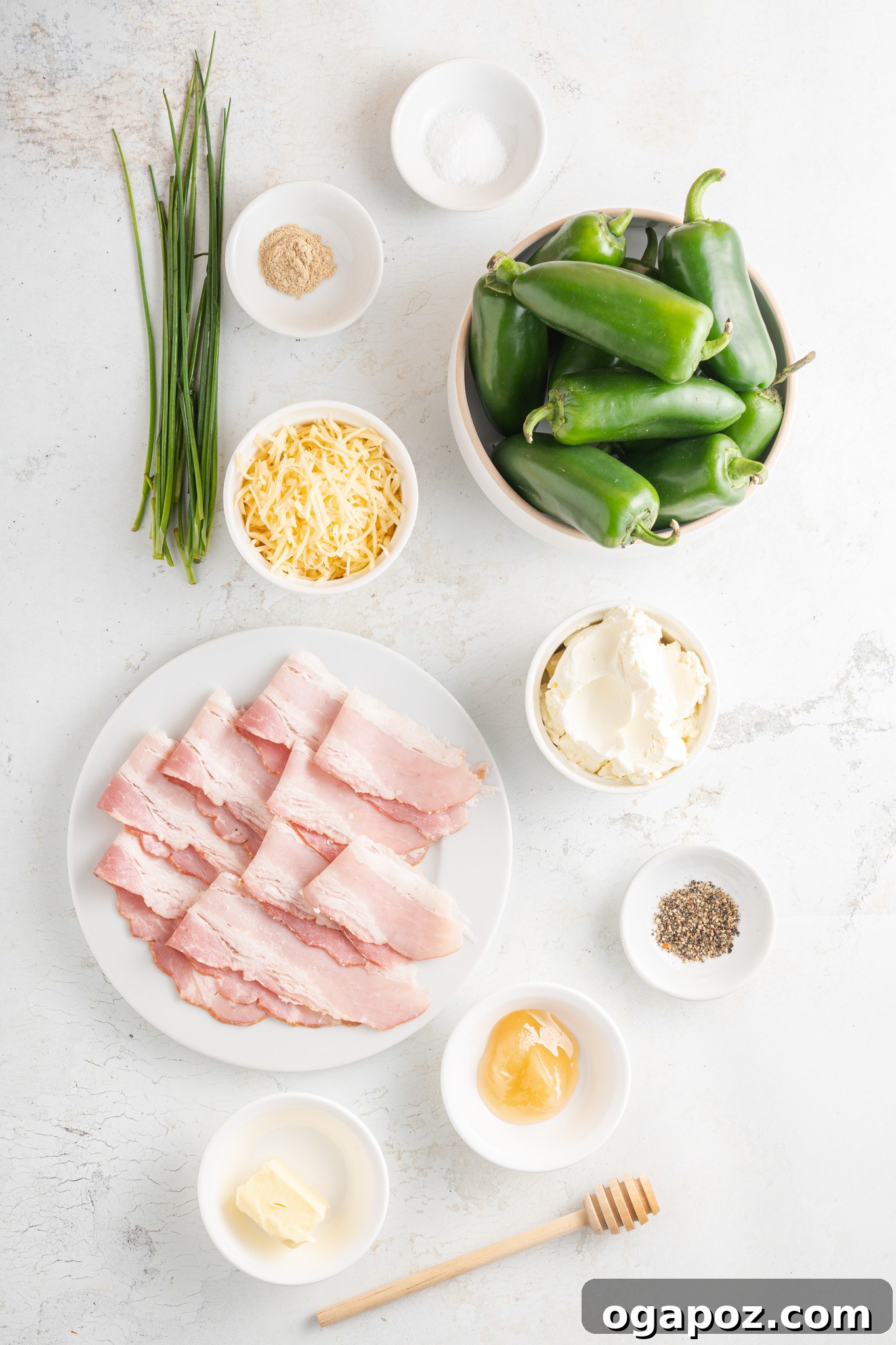 Bacon-Wrapped Jalapeño Bombs 3 Fresh ingredients laid out for Bacon-Wrapped Jalapeño Poppers, including jalapeños, bacon, various cheeses, and chives.