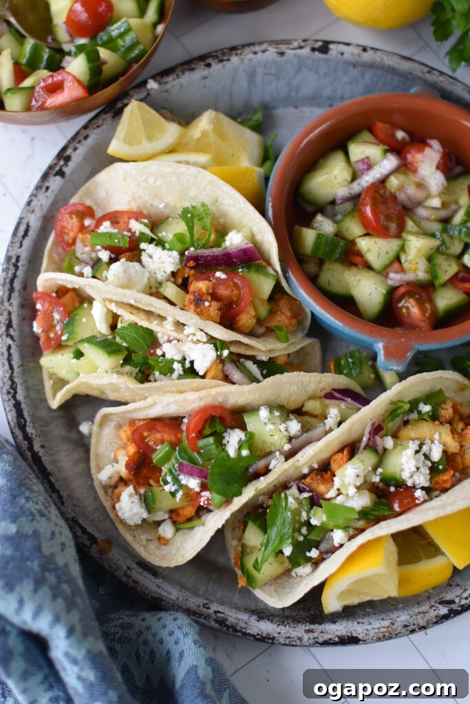 Mediterranean-Inspired Tofu Tacos 4 Three Mediterranean Style Tofu Tacos on a rustic grey plate, showcasing the flavorful tofu and fresh toppings.