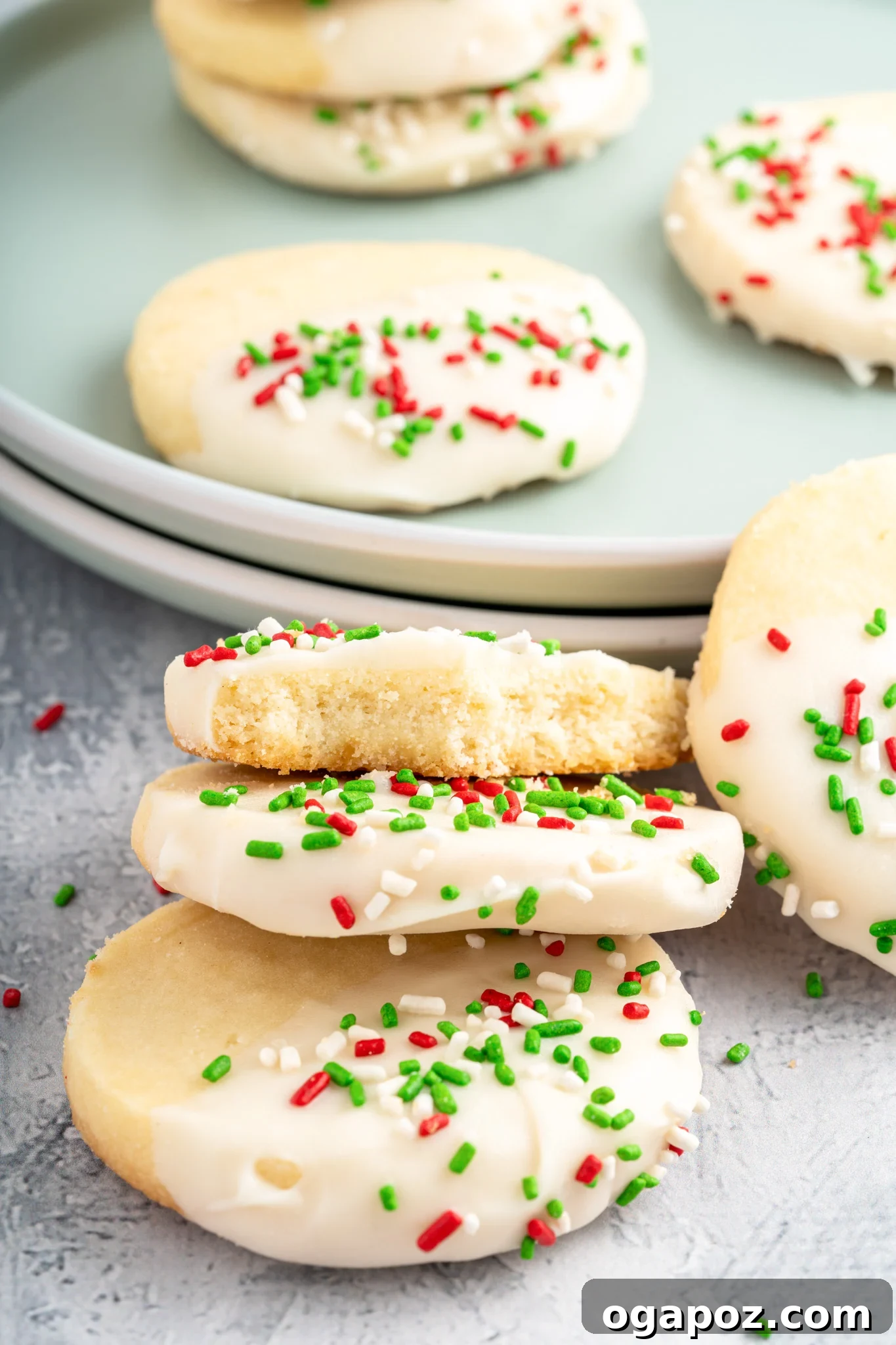 Buttery Christmas Shortbread Bliss 11 Beautifully decorated Christmas Shortbread Cookies, glistening with white chocolate and colorful sprinkles, arranged on a cooling rack.