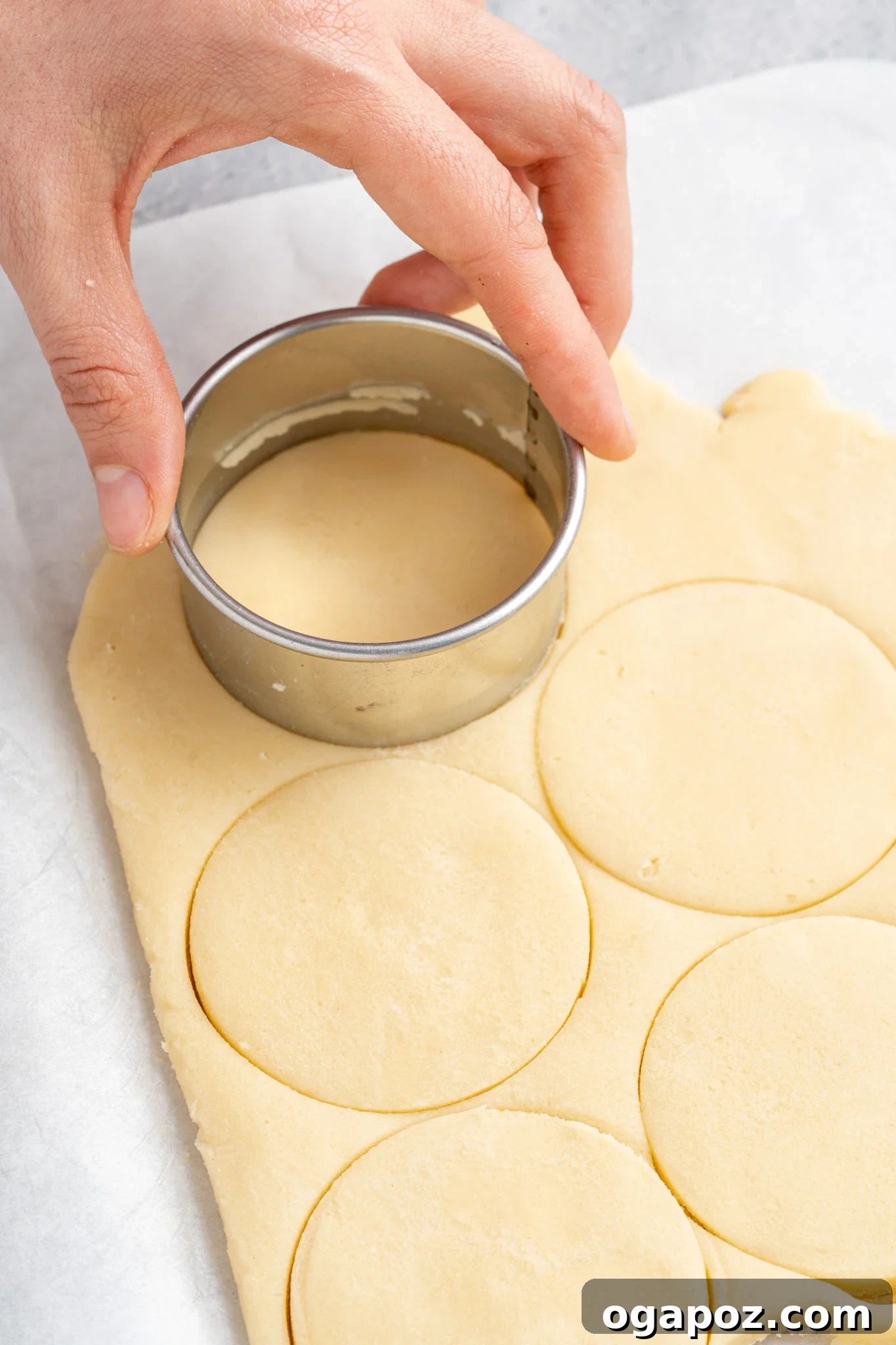 Buttery Christmas Shortbread Bliss 8 Various Christmas-themed cookie cutters and freshly cut shortbread dough shapes laid out on parchment paper, ready for baking.