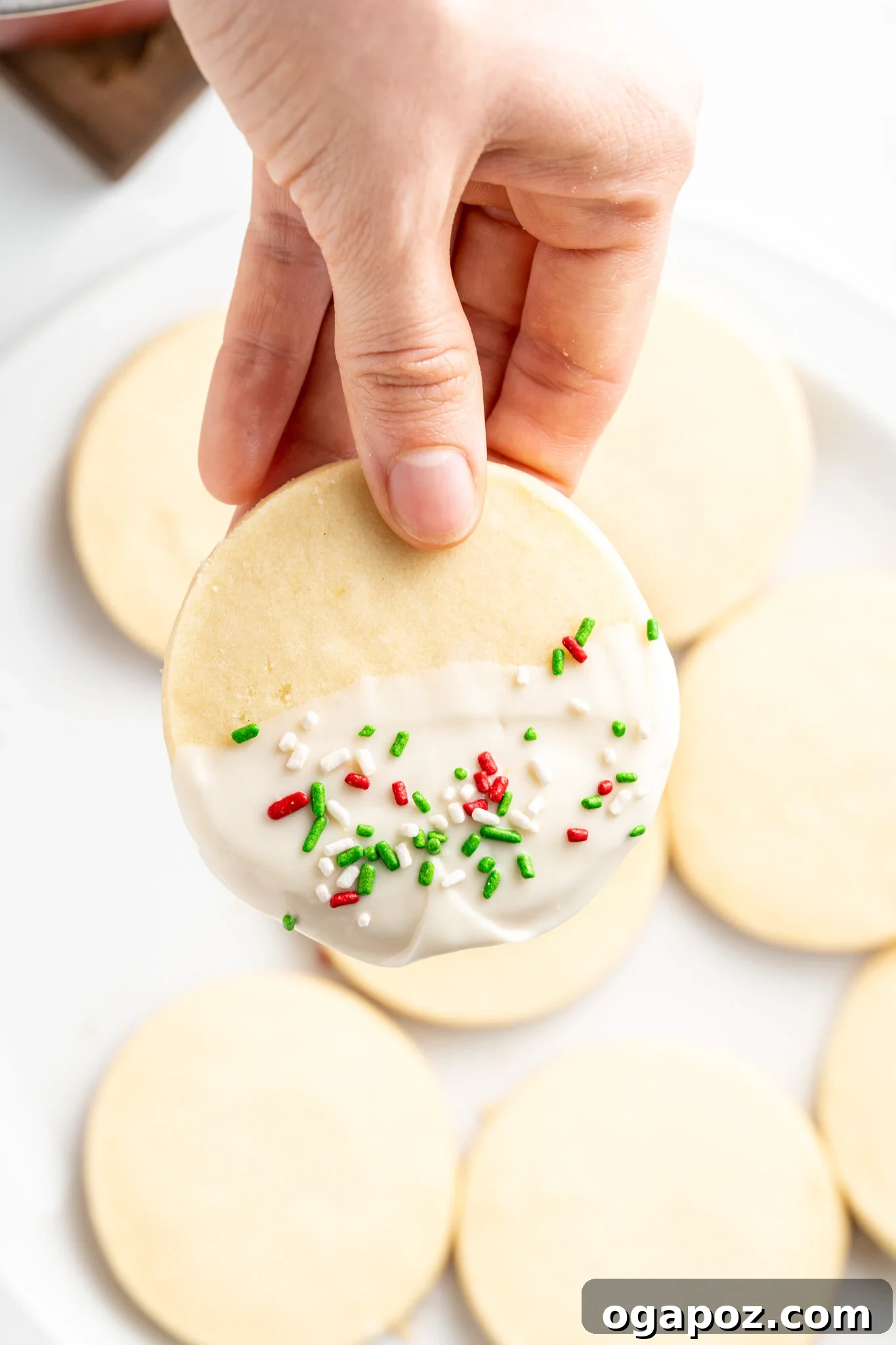 Buttery Christmas Shortbread Bliss 10 A Christmas Shortbread Cookie being dipped into melted white chocolate, a crucial step for its festive decoration.
