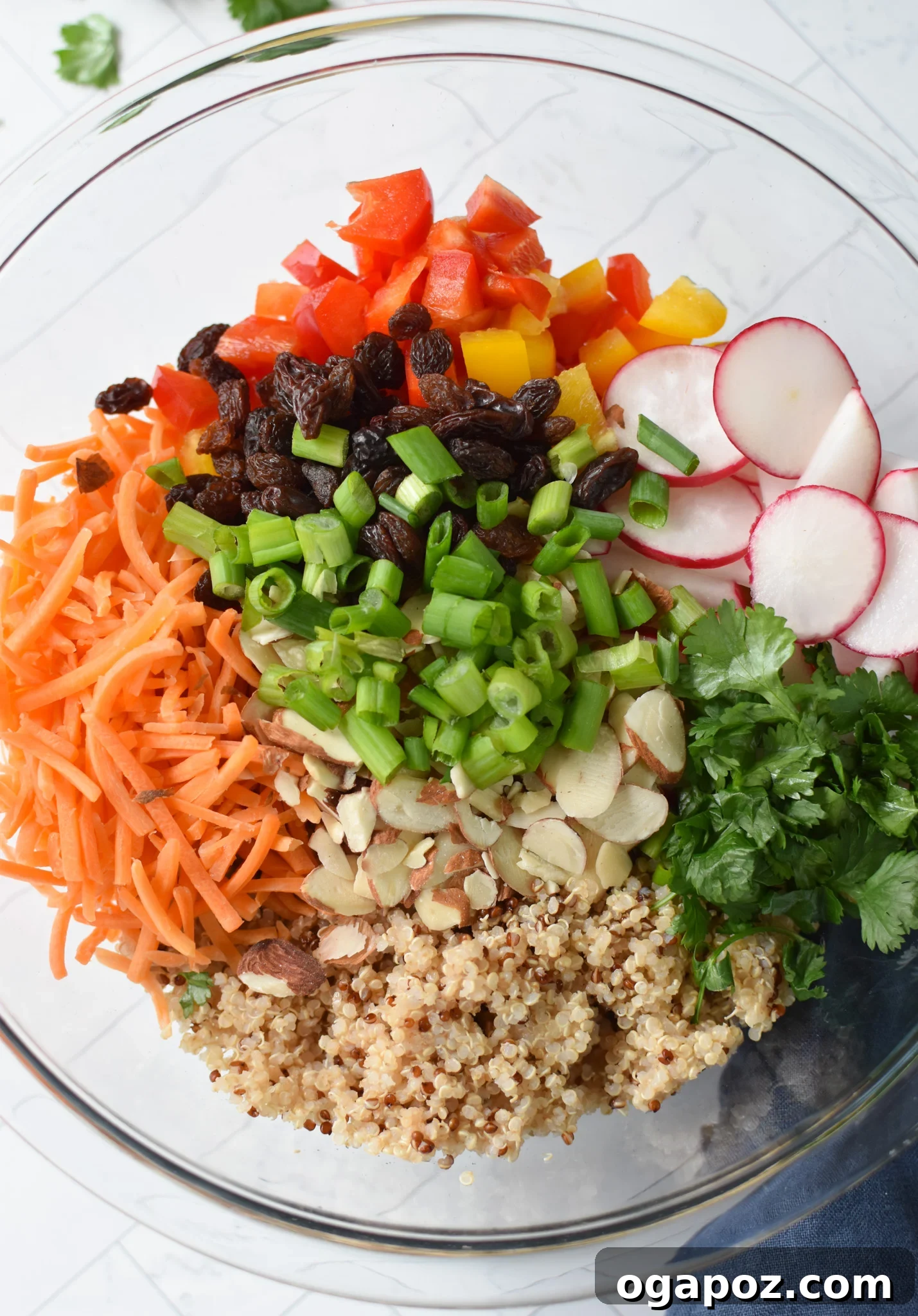 All the prepped ingredients for Curried Quinoa Salad placed in a large mixing bowl, ready to be tossed.