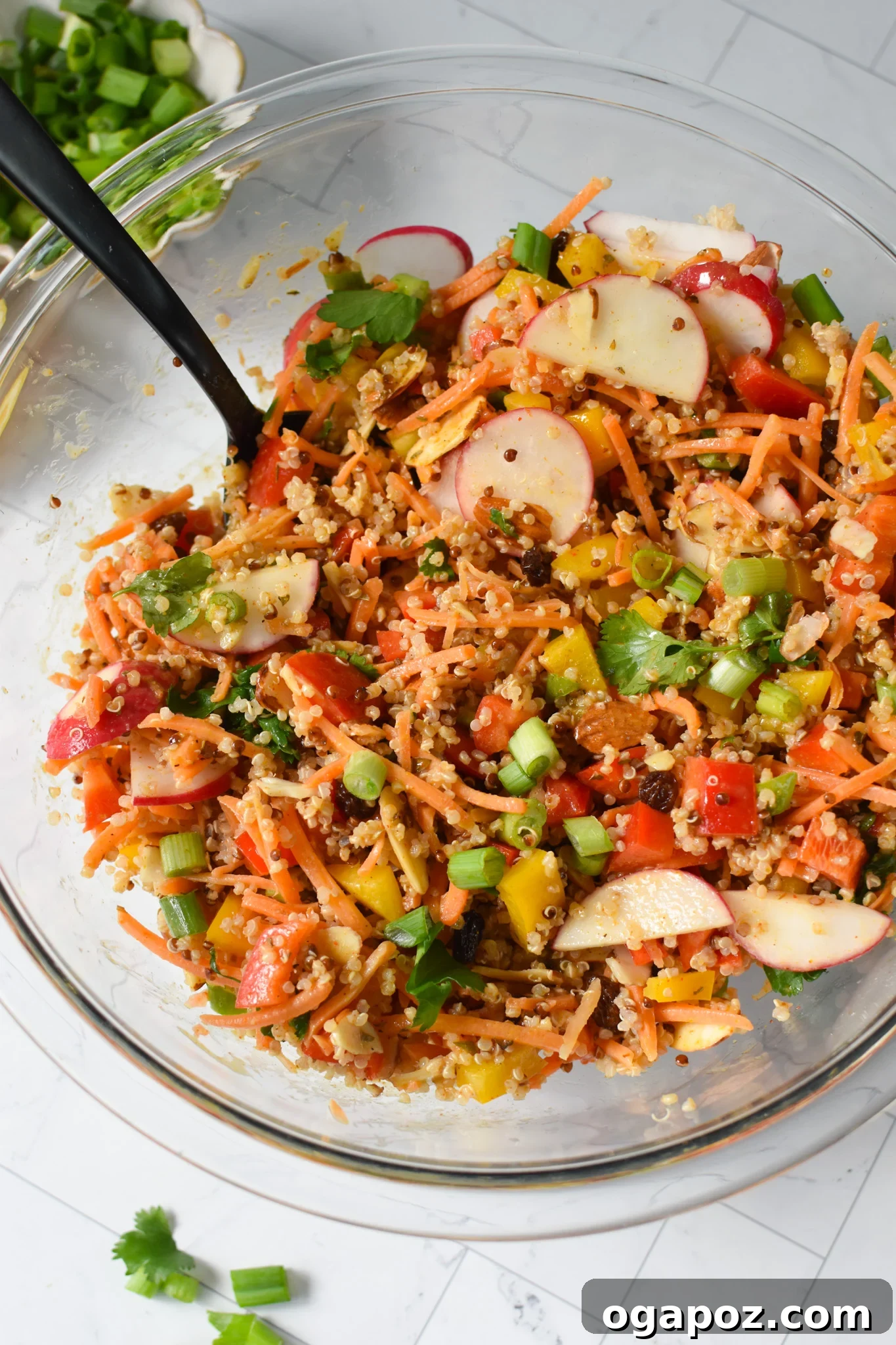 Curried Quinoa Salad ingredients thoroughly mixed in a large bowl, coated with the dressing.