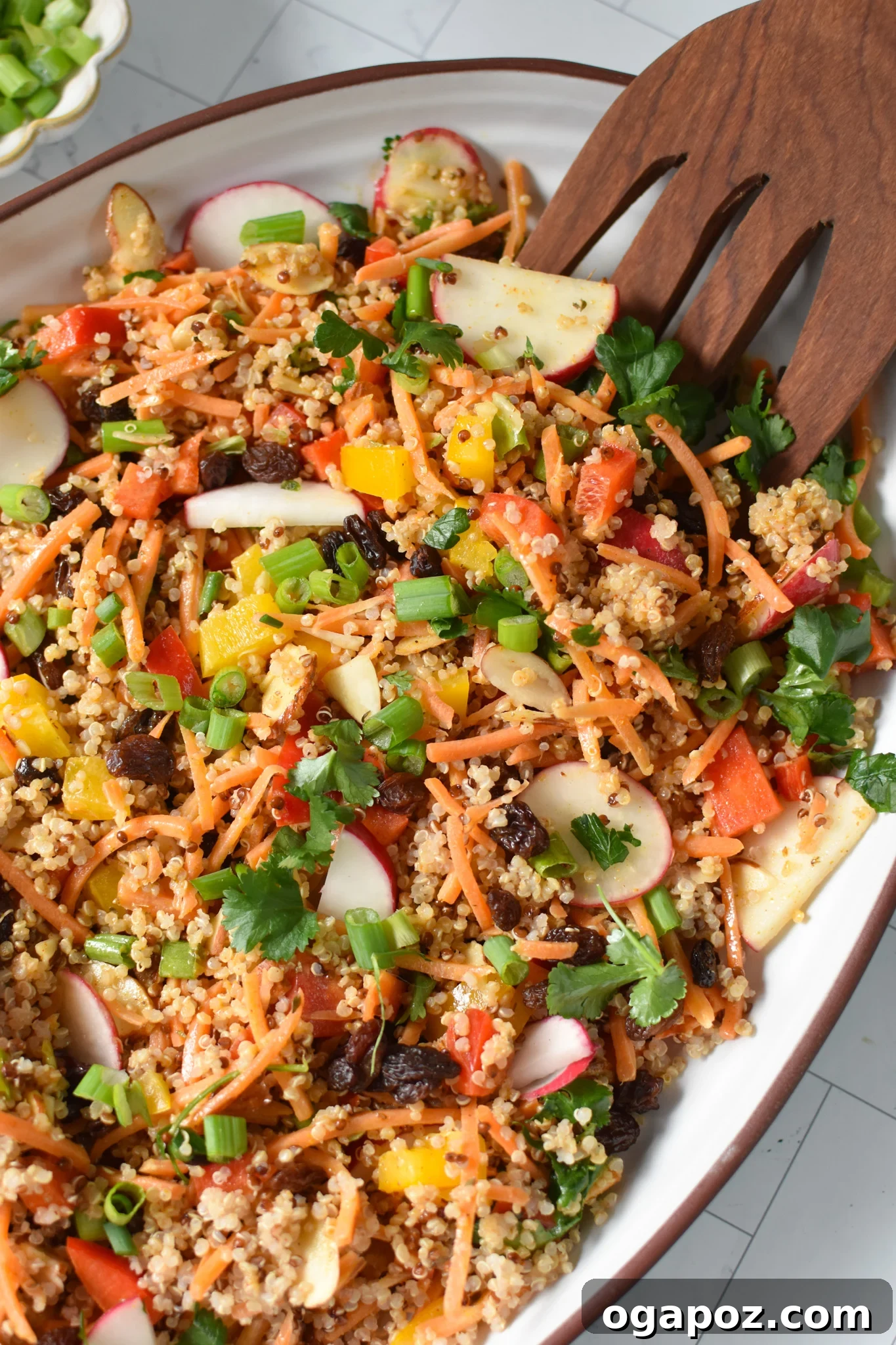 Curried Quinoa Salad beautifully presented on a large white platter, garnished with fresh herbs.