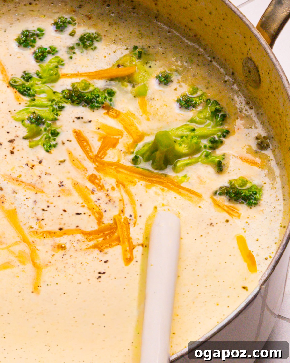 15 Trendsetting Recipes to Savor in 2025 12 A large pot of rich and creamy Broccoli Cheddar Soup, garnished with fresh herbs, with a ladle resting inside, ready to be served.