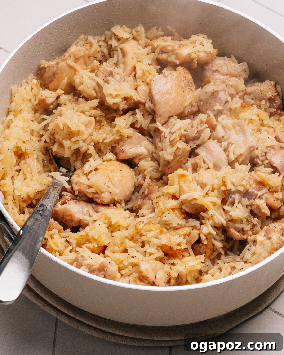 15 Trendsetting Recipes to Savor in 2025 16 A comforting one-pot chicken and rice dish, showing tender chicken pieces nestled among fluffy rice, garnished with fresh parsley and a side of green beans, indicating a complete meal.