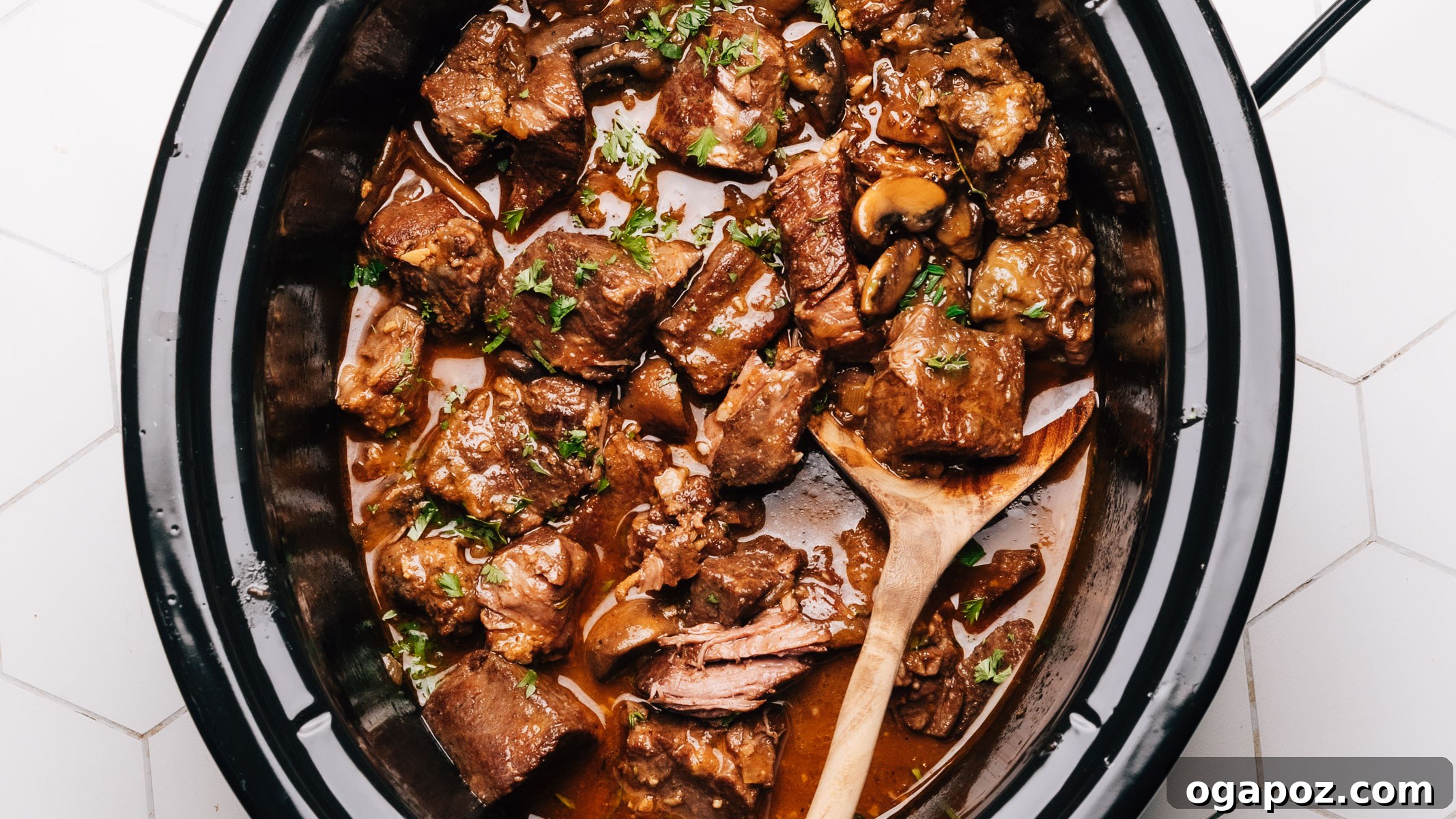 15 Trendsetting Recipes to Savor in 2025 3 A close-up of Crockpot Beef Tips, showing tender beef cubes swimming in a rich, savory brown gravy, garnished with fresh parsley and ready to be served over mashed potatoes.