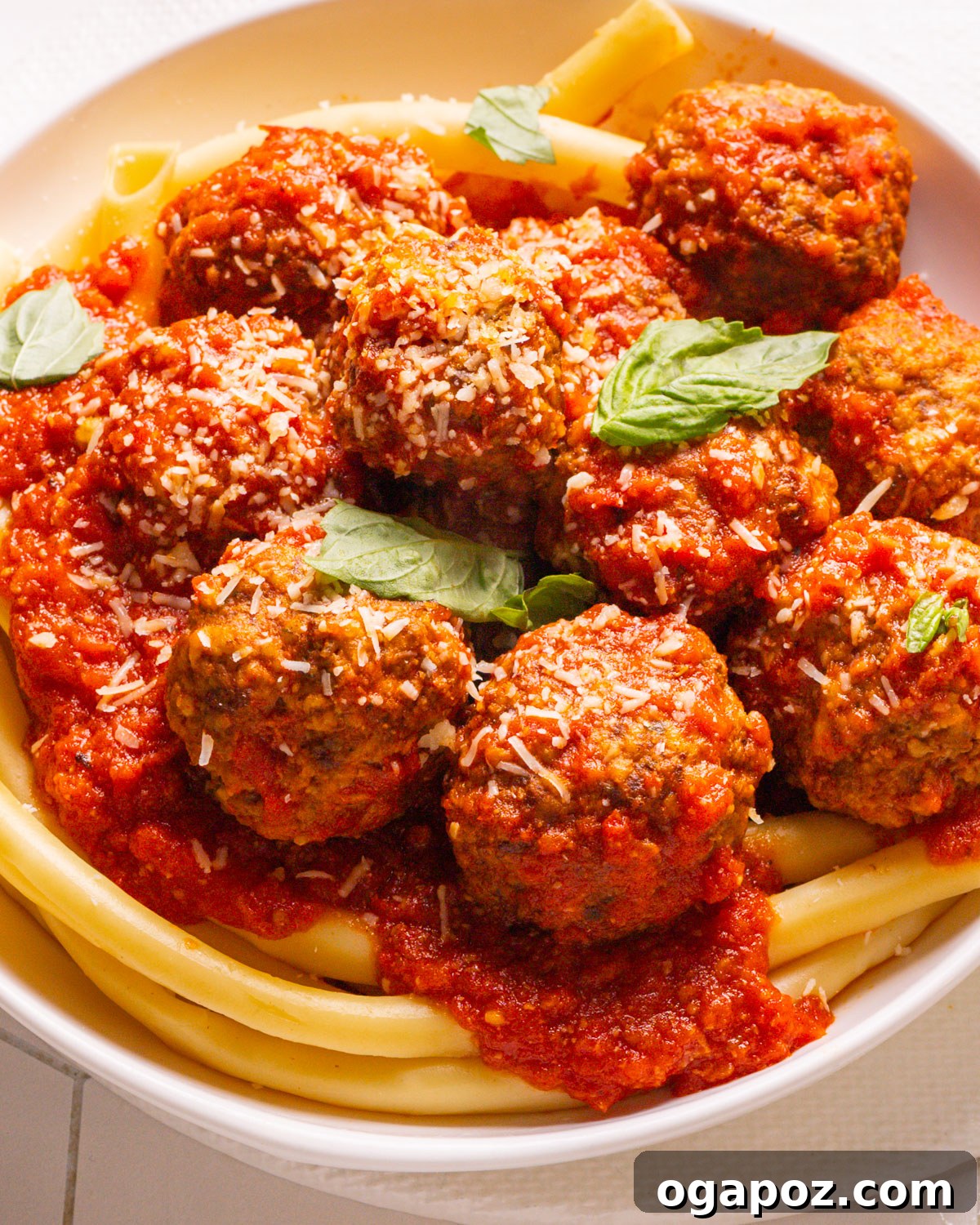 15 Trendsetting Recipes to Savor in 2025 8 A plate piled high with perfectly browned and glistening meatballs, generously coated in sauce and ready to be served with pasta or in a sandwich.