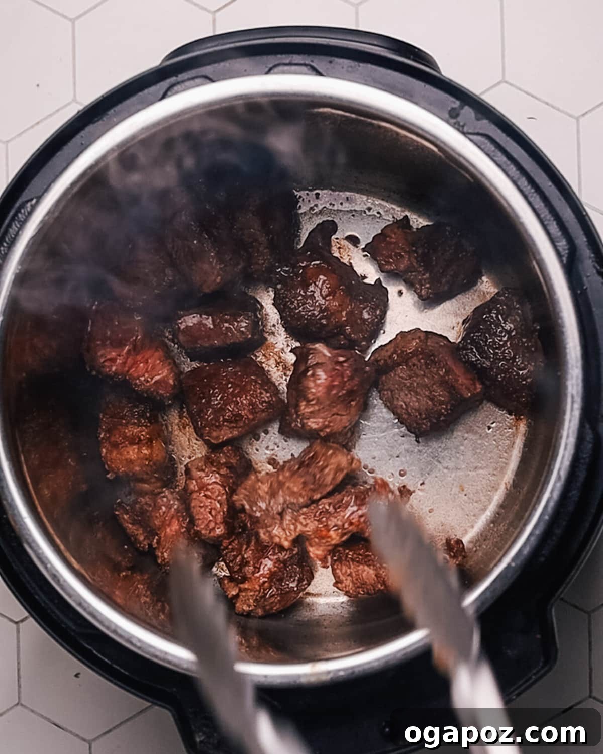 Step 1: Browning the beef in a pressure cooker to develop deep flavors.