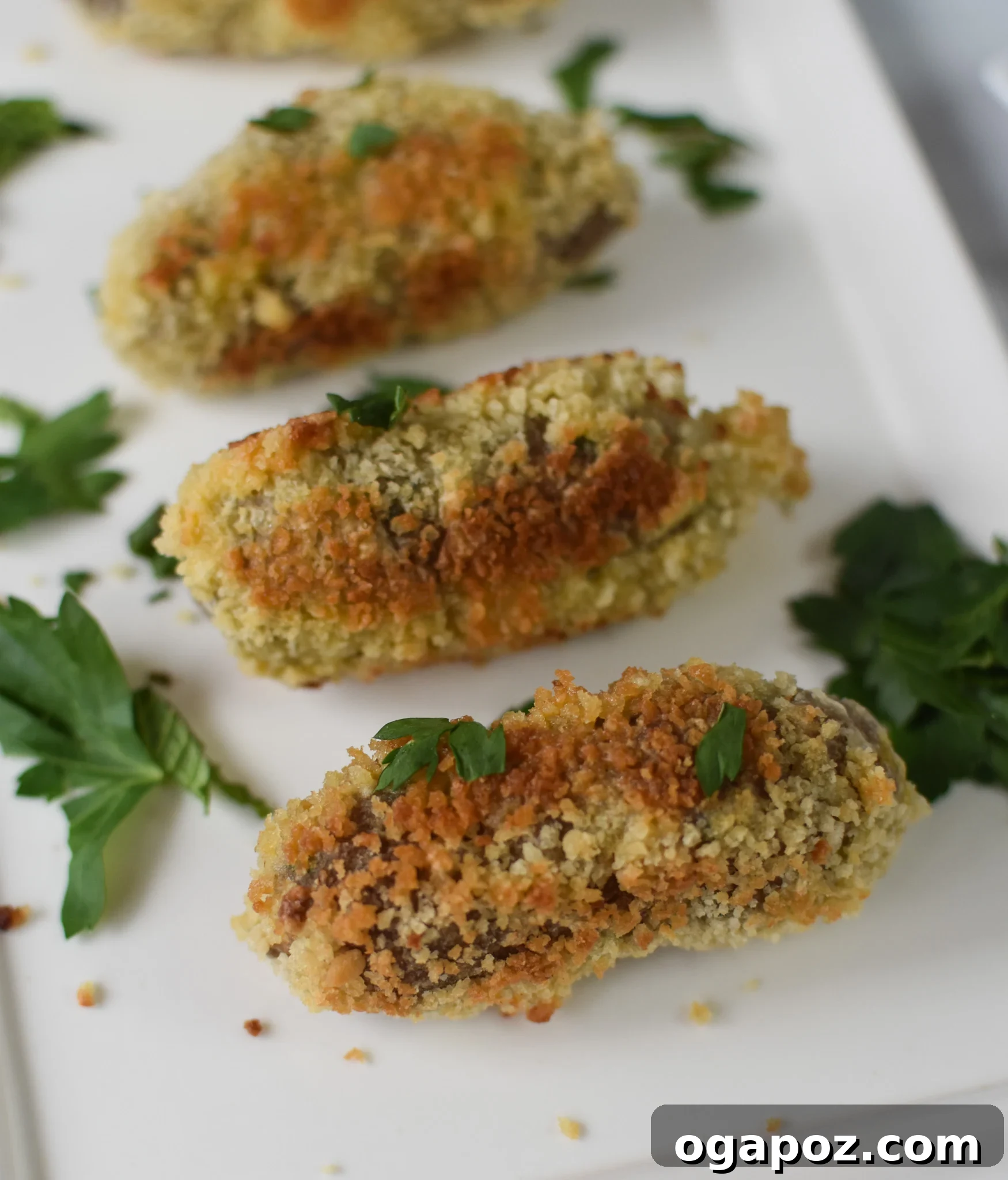 Crispy Lamb Bites 2 Crispy golden Lamb Croquettes served on a white plate, garnished with fresh herbs.