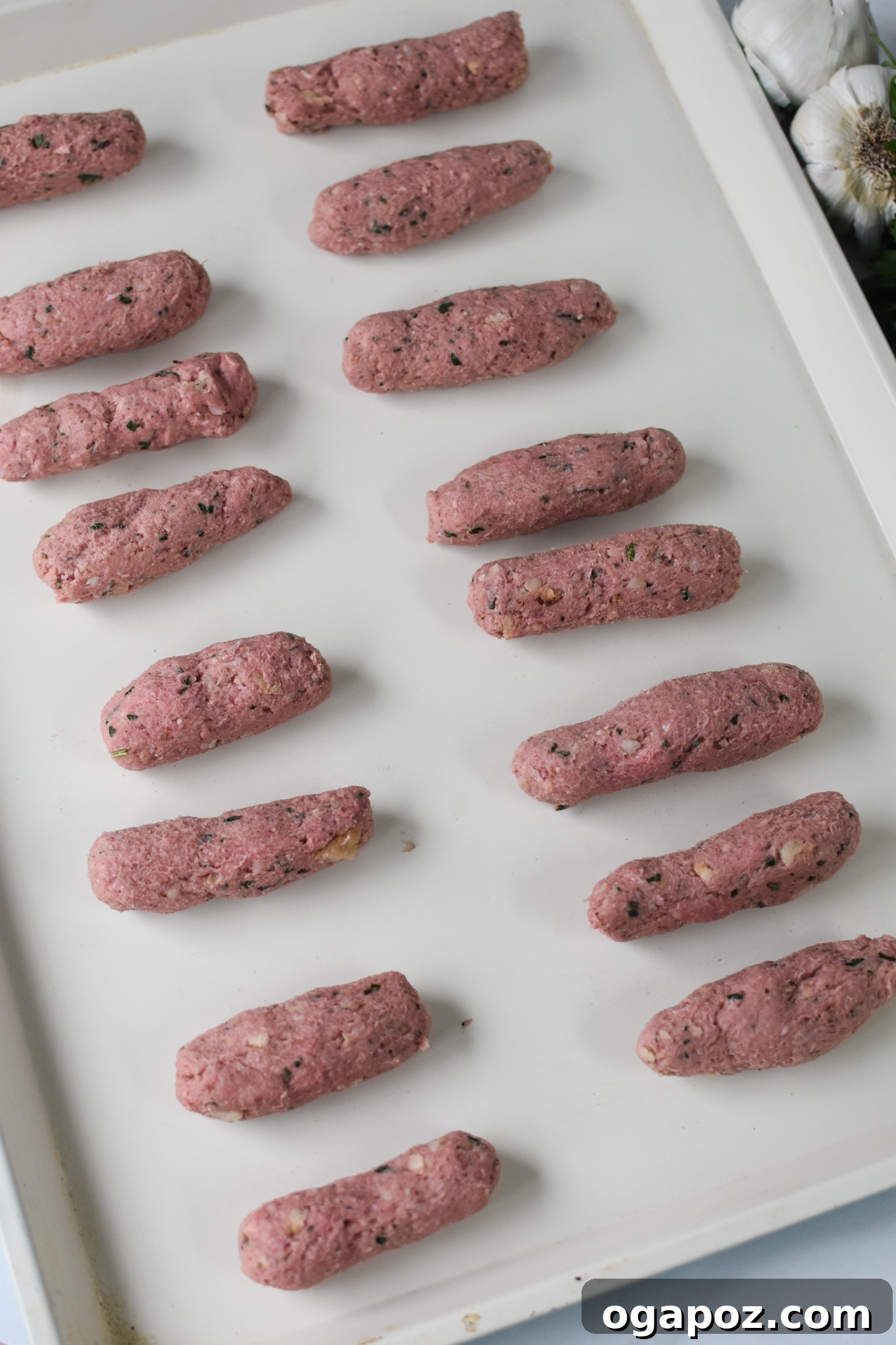 Crispy Lamb Bites 7 Raw lamb croquette logs arranged on a baking sheet, ready for coating.