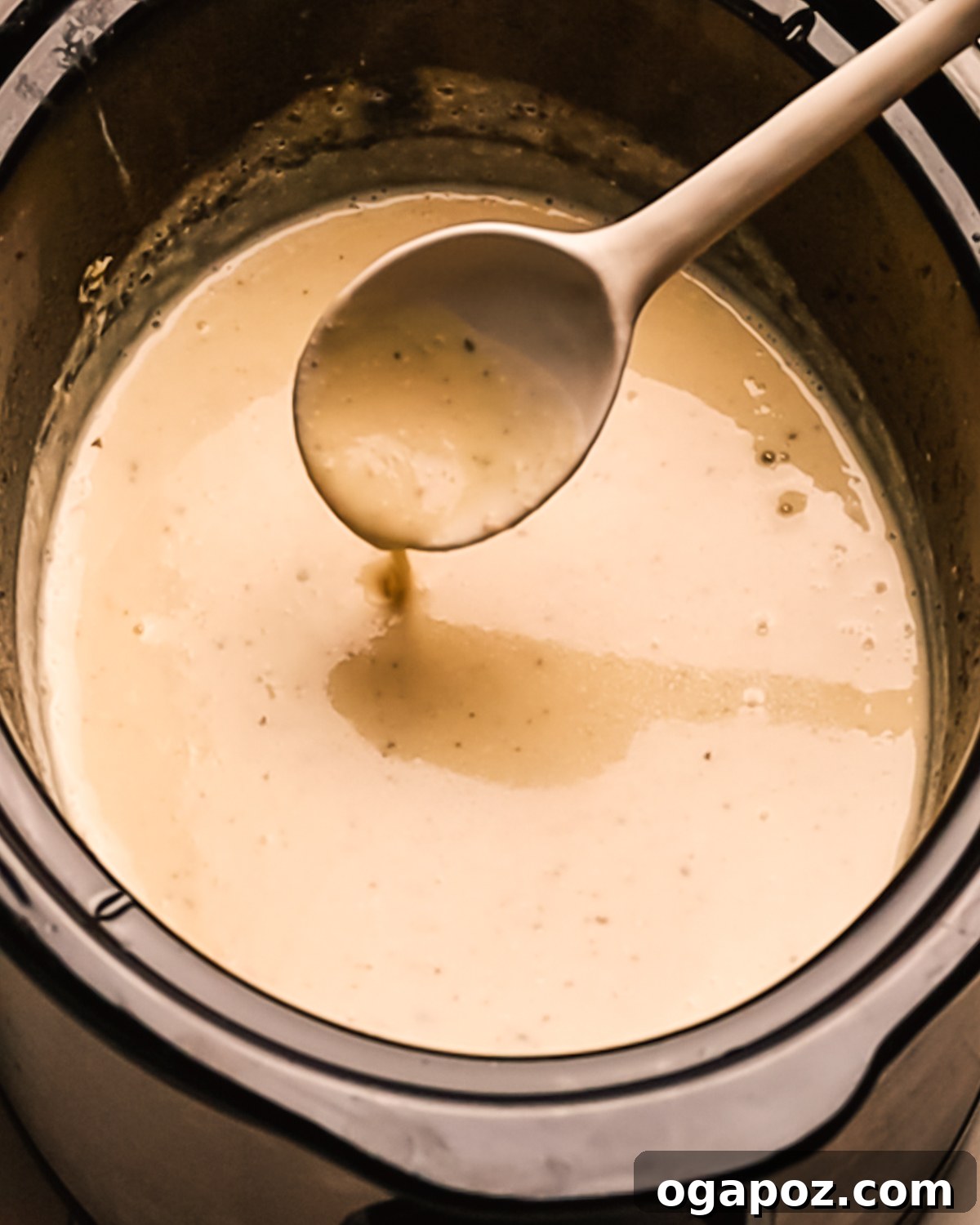 Creamy Slow Cooker Chicken Alfredo 7 Step 4: Creamy Alfredo sauce simmering in the slow cooker with chicken.