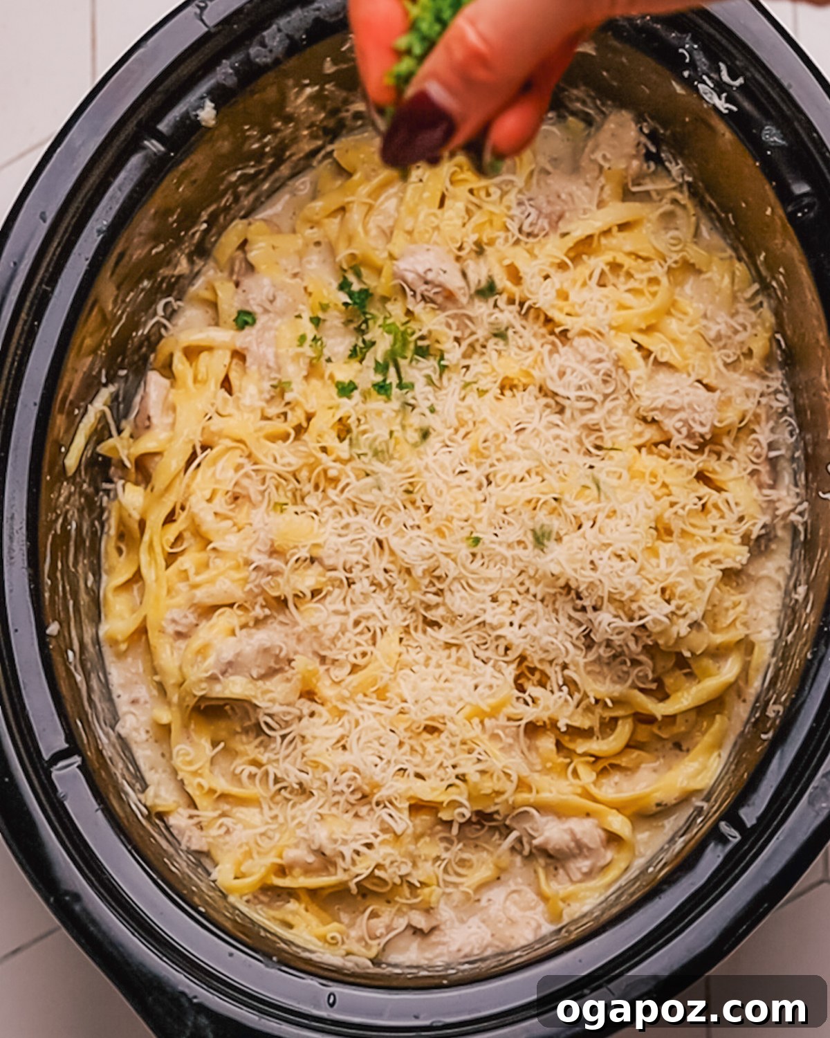 Creamy Slow Cooker Chicken Alfredo 9 Step 6: Combining shredded chicken, Alfredo sauce, and fettuccine pasta in the slow cooker.