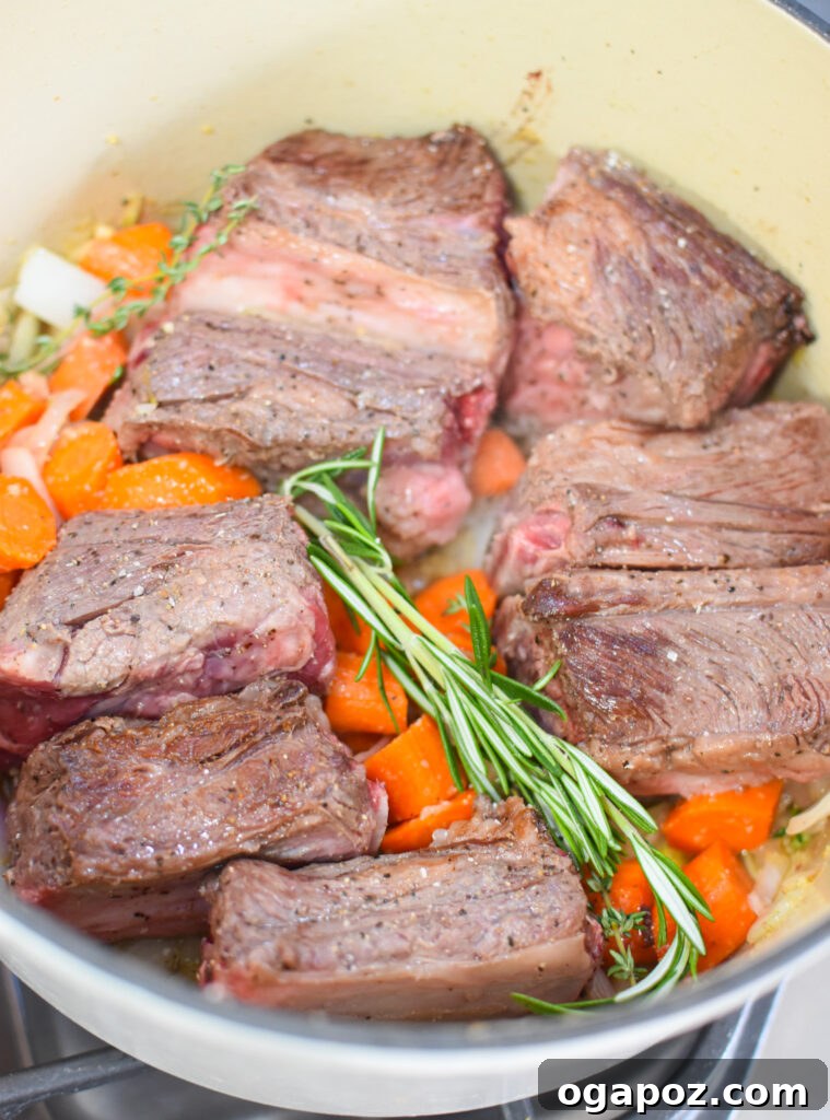 Rich & Tangy Cranberry Short Ribs 7 Sautéed vegetables, including carrots, onions, and shallots, cooking in a Dutch oven after the short ribs have been seared.