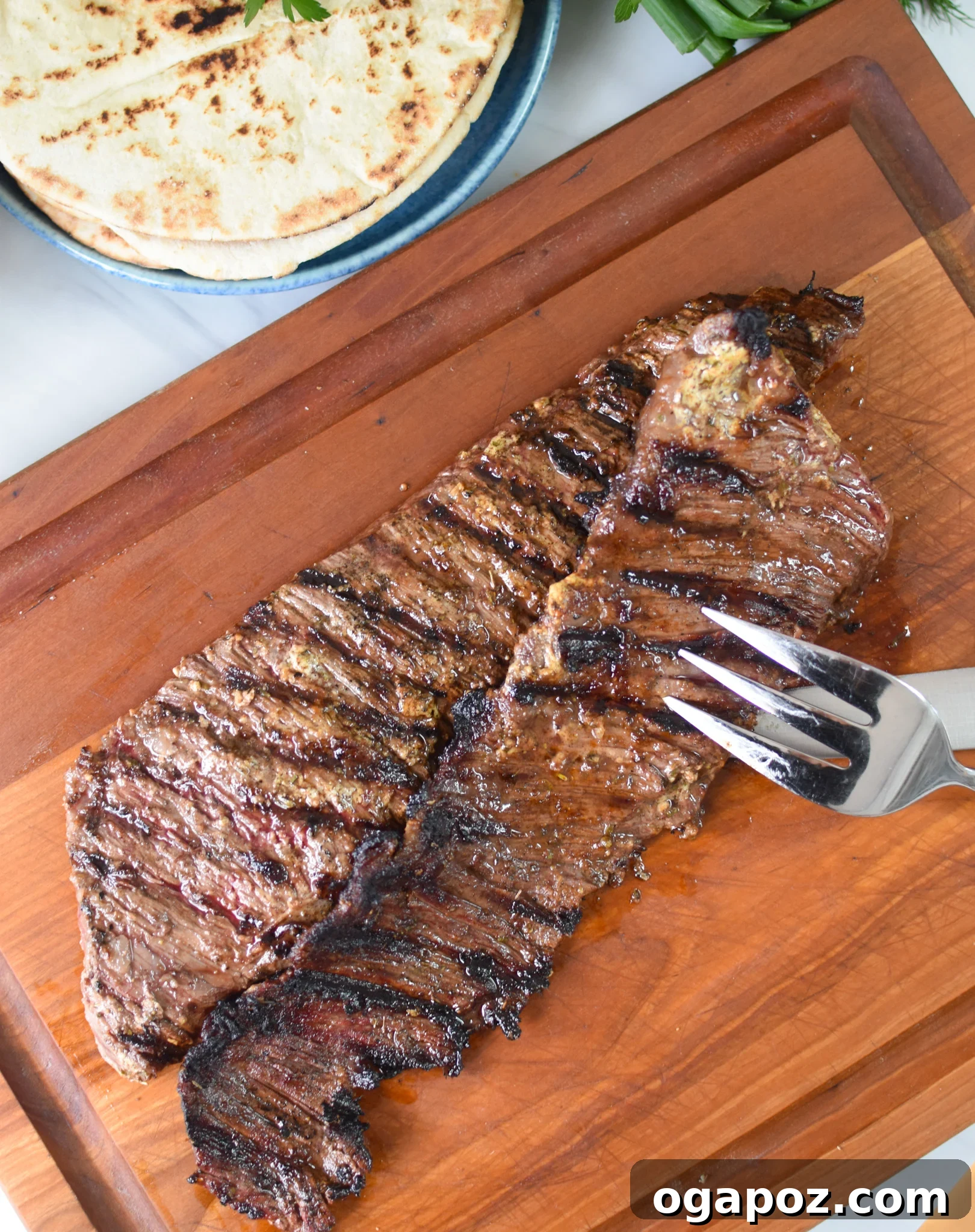Quick Beef Gyro Wraps 11 Thinly sliced grilled skirt steak on a cutting board, ready for gyros