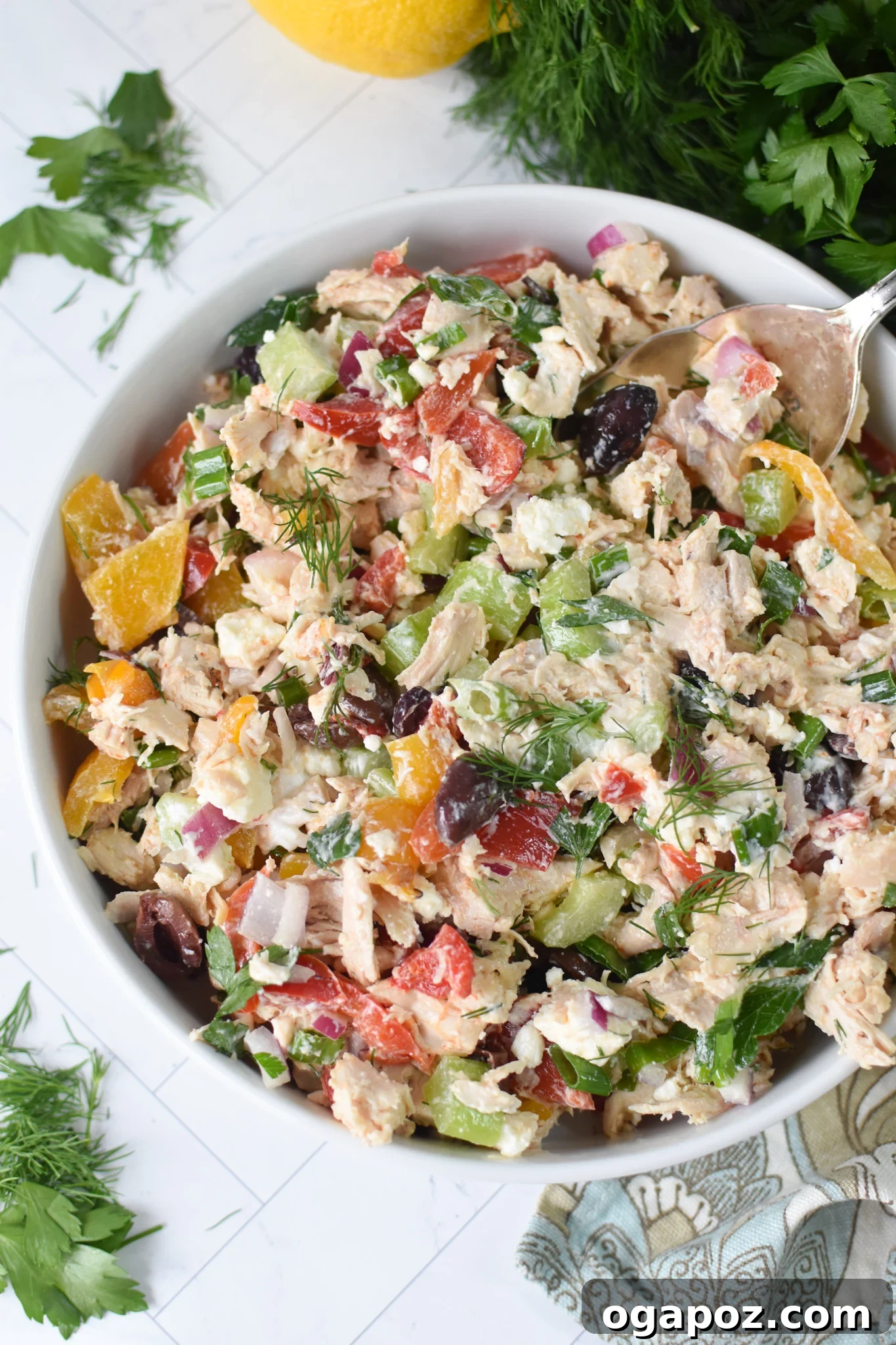 Vibrant Mediterranean Chicken Salad 2 Healthy Mediterranean Chicken Salad in a white bowl, garnished with fresh parsley.