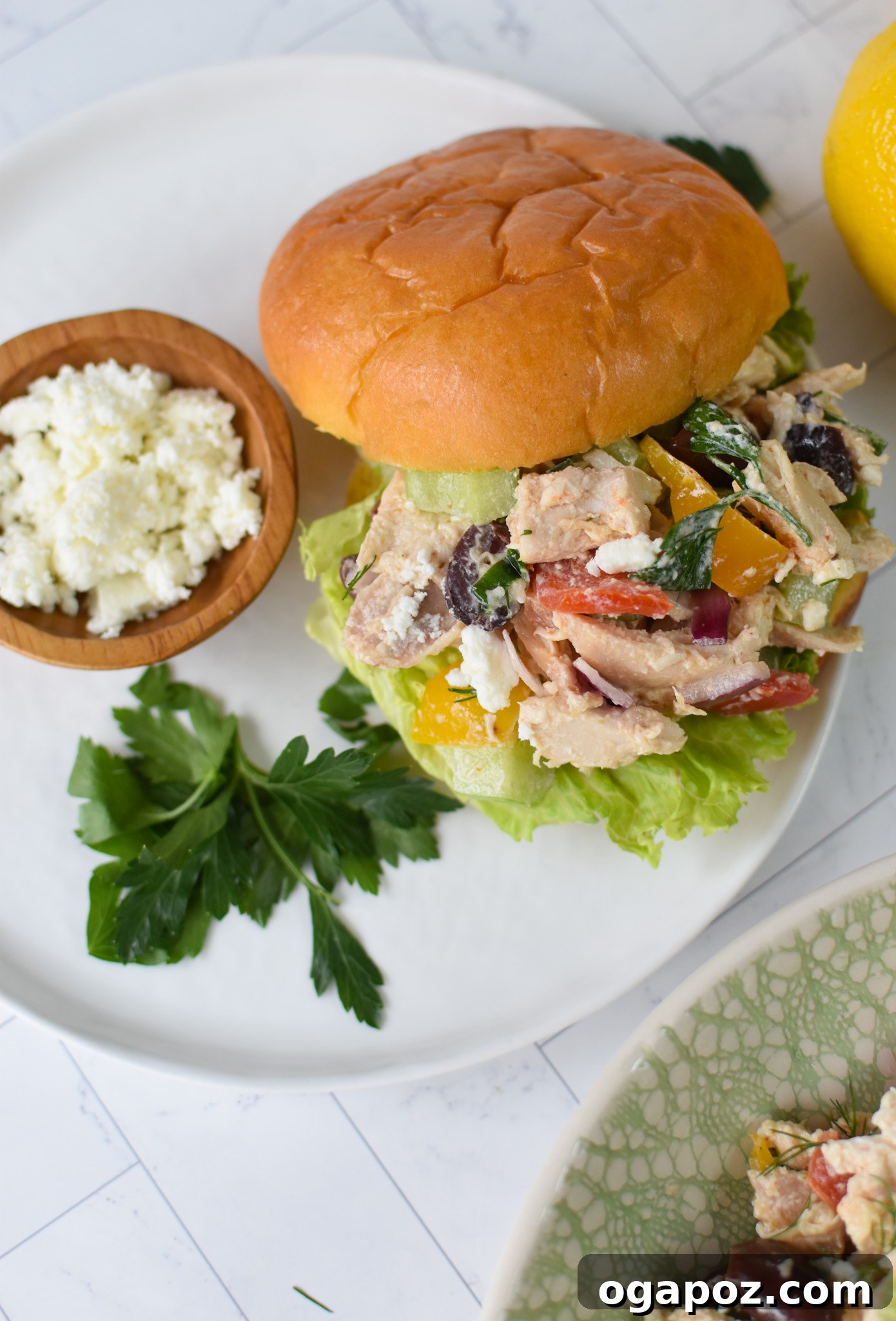 Vibrant Mediterranean Chicken Salad 7 Healthy Mediterranean Chicken Salad served elegantly on a fresh brioche bun.