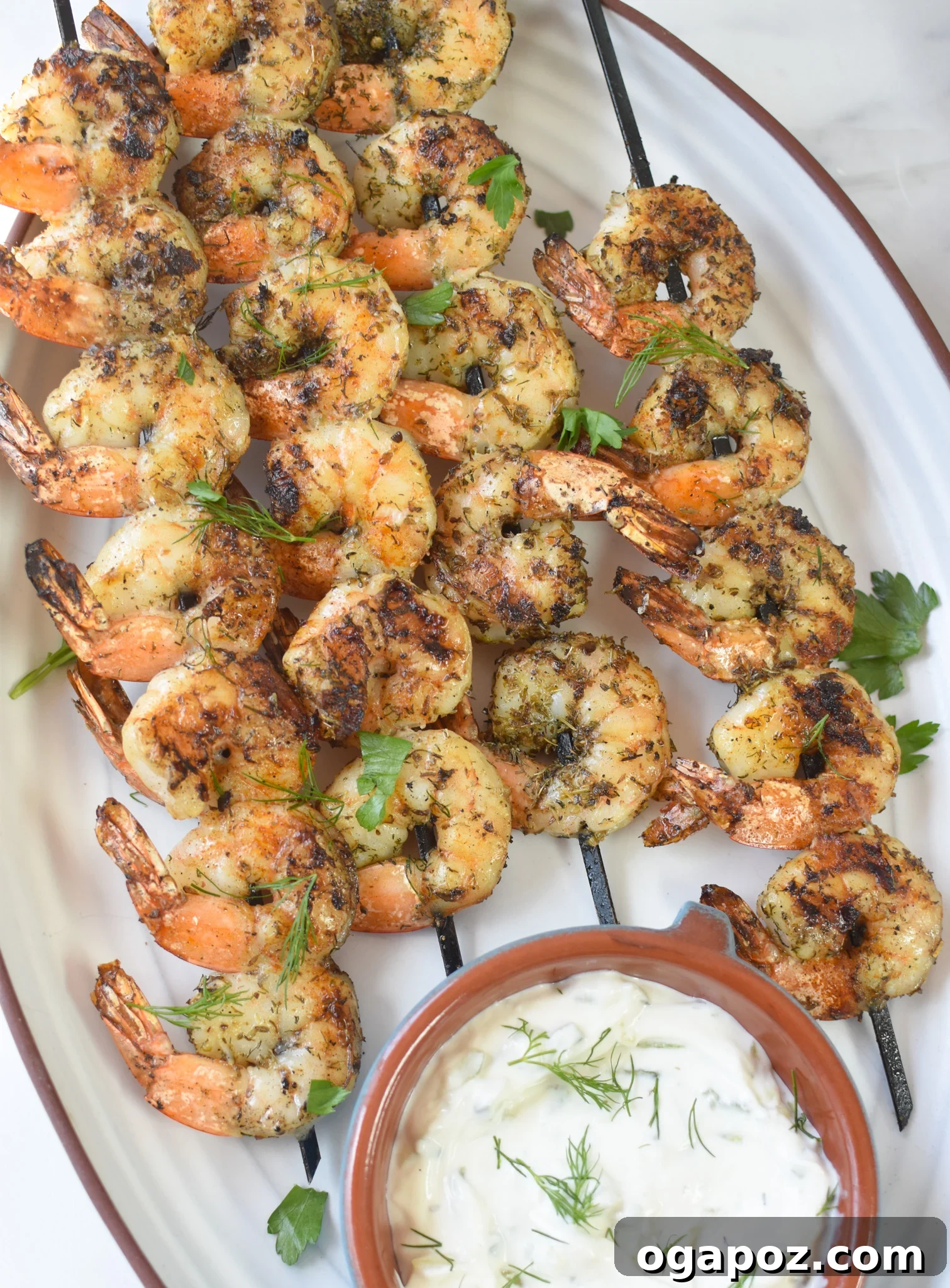 Zesty Greek Shrimp Marinade 2 Plump grilled Greek shrimp served on a pristine white platter, garnished with fresh herbs and lemon wedges.