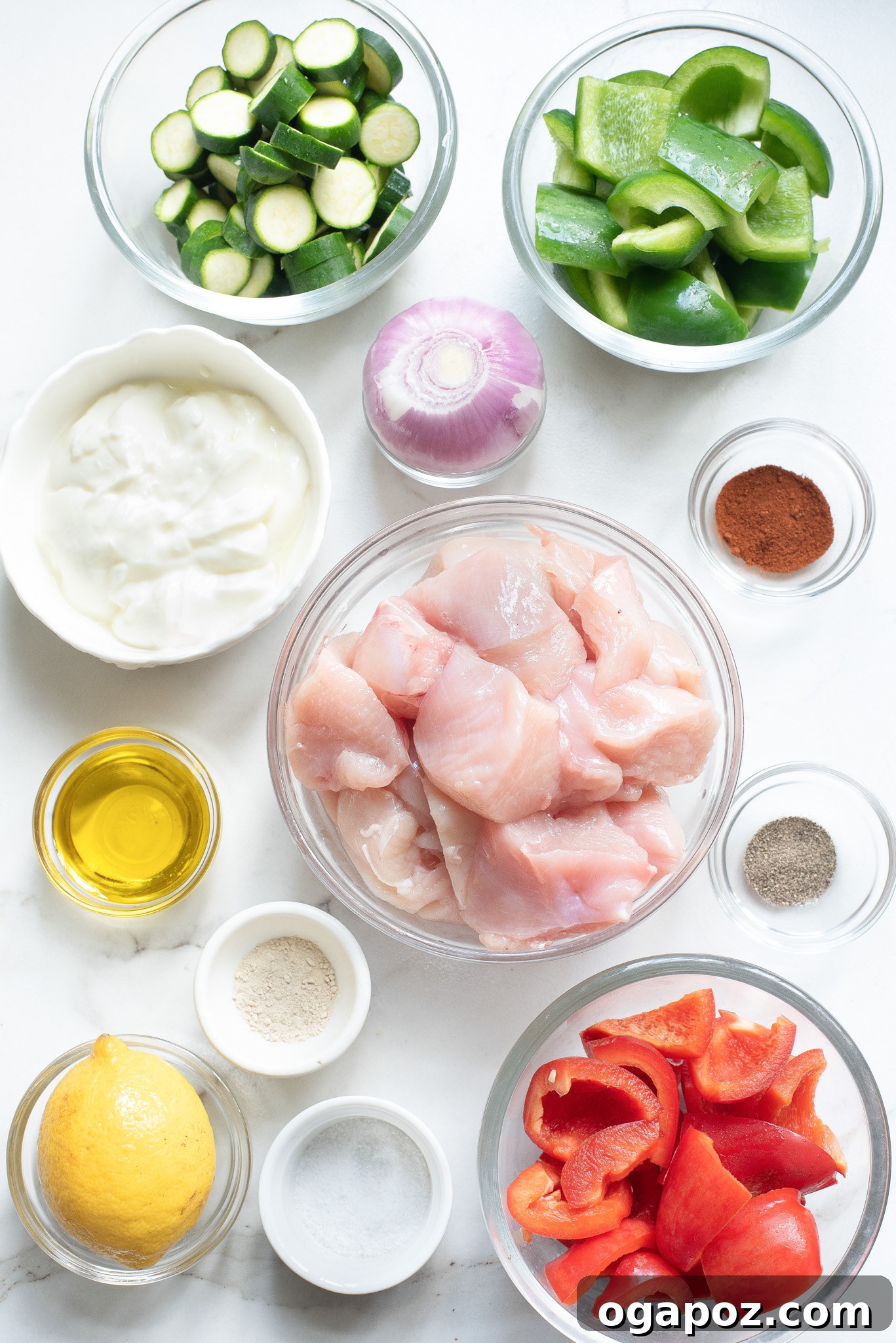 Zesty Greek Lemon Chicken Skewers 3 Ingredients laid out for Greek Marinated Chicken Kabobs with Lemon including chicken, bell peppers, zucchini, red onion, lemon, Greek yogurt, olive oil, and spices.