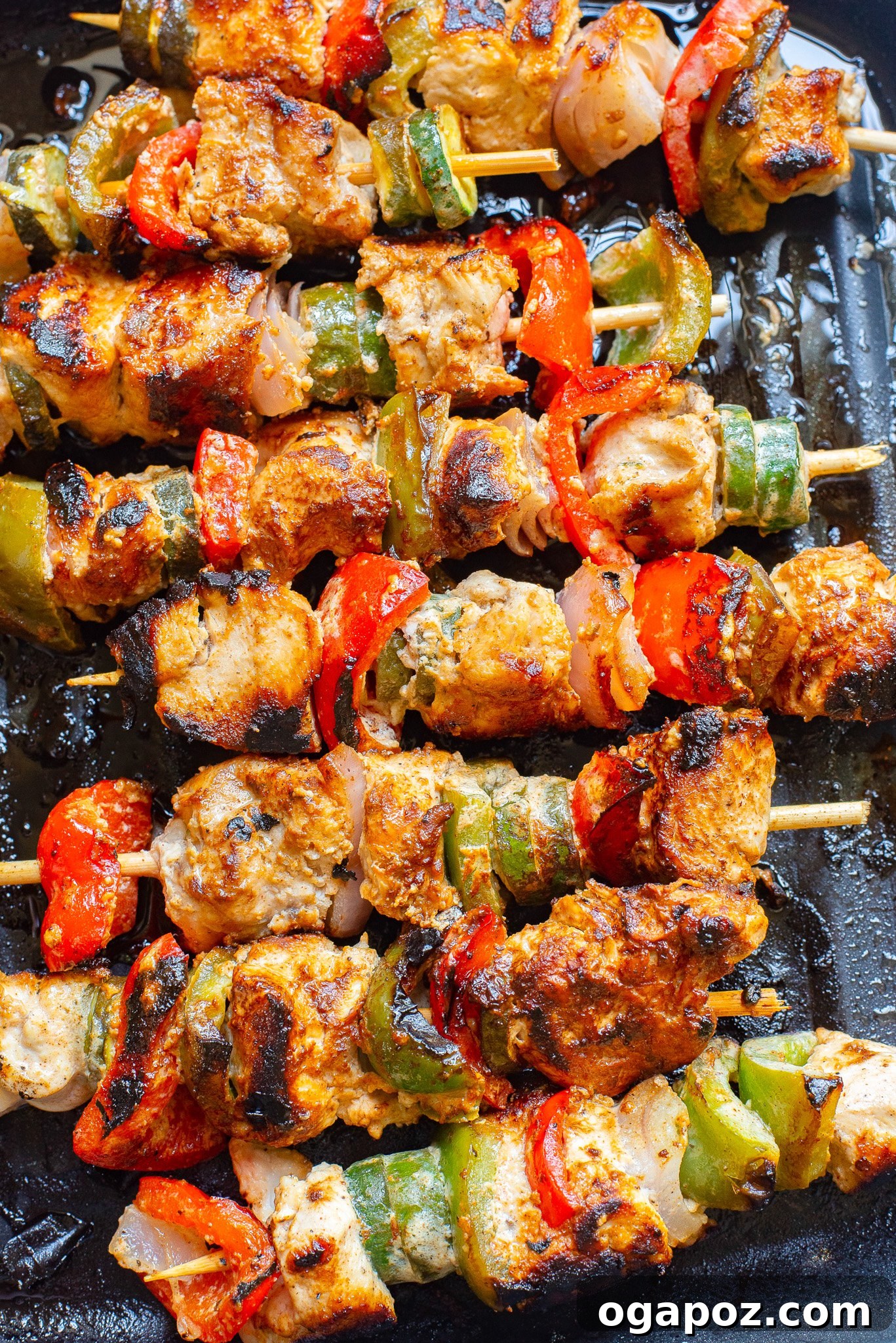 Zesty Greek Lemon Chicken Skewers 4 Greek Marinated Chicken Kabobs with Lemon cooking on an outdoor grill, showing char marks.