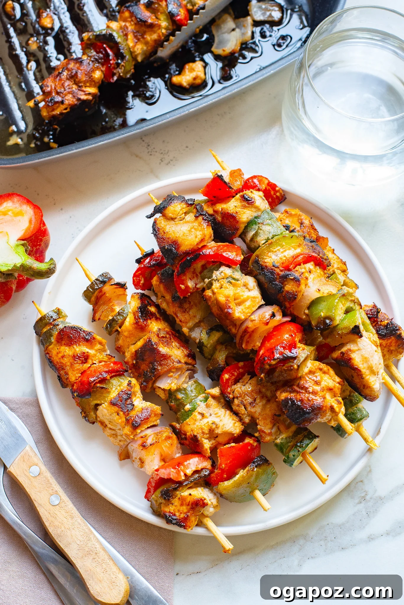 Zesty Greek Lemon Chicken Skewers 7 Plated Greek Marinated Chicken Kabobs with Lemon, garnished with fresh herbs and a side of dipping sauce.