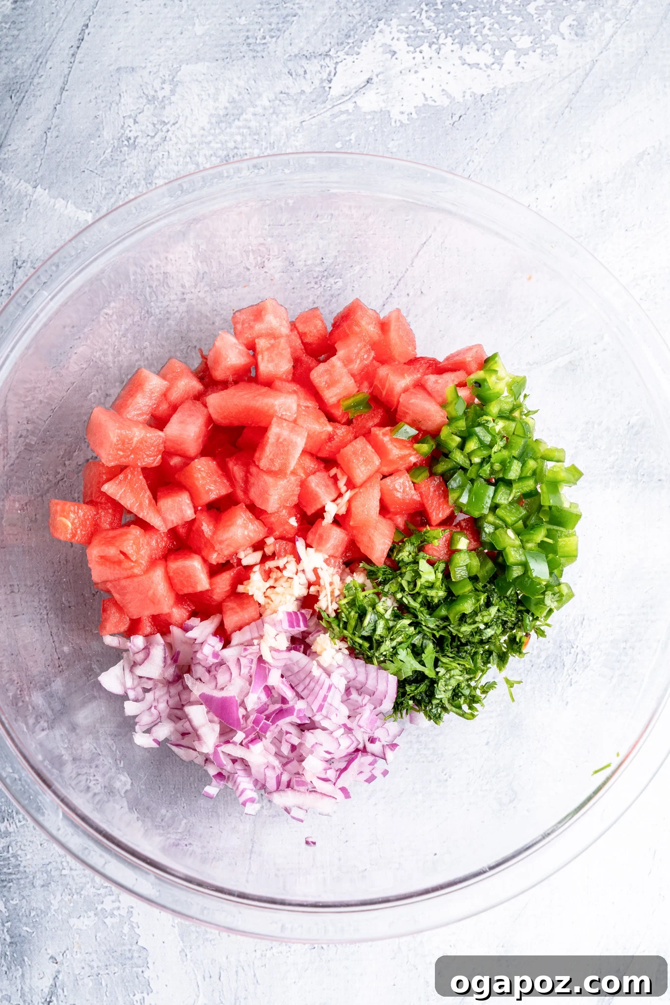 Summer Watermelon Salsa 7 Easy Watermelon Salsa ingredients mixed in a clear glass bowl, ready to be seasoned.