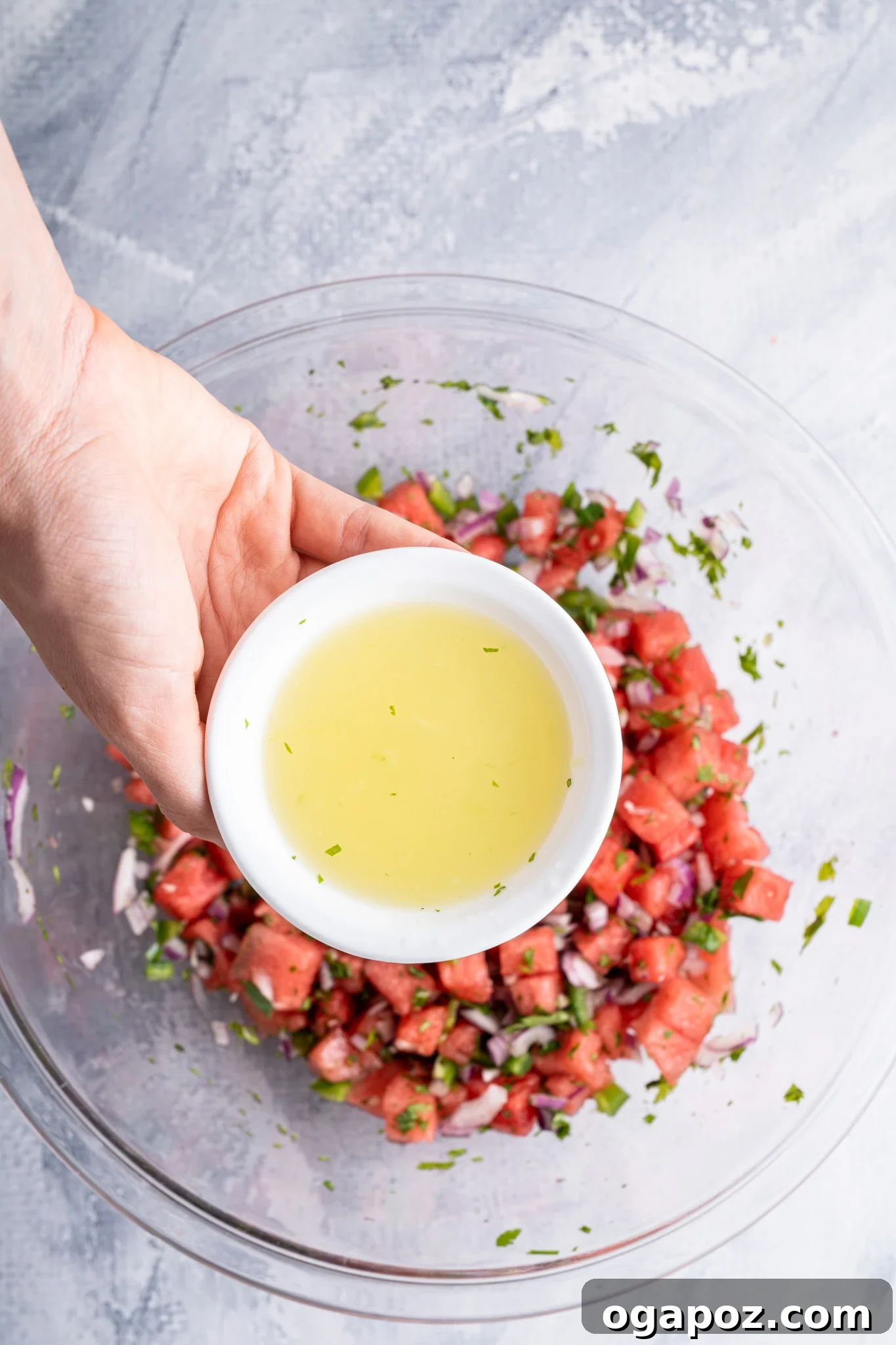 Summer Watermelon Salsa 8 Fresh lime juice being squeezed over a bowl of Easy Watermelon Salsa.