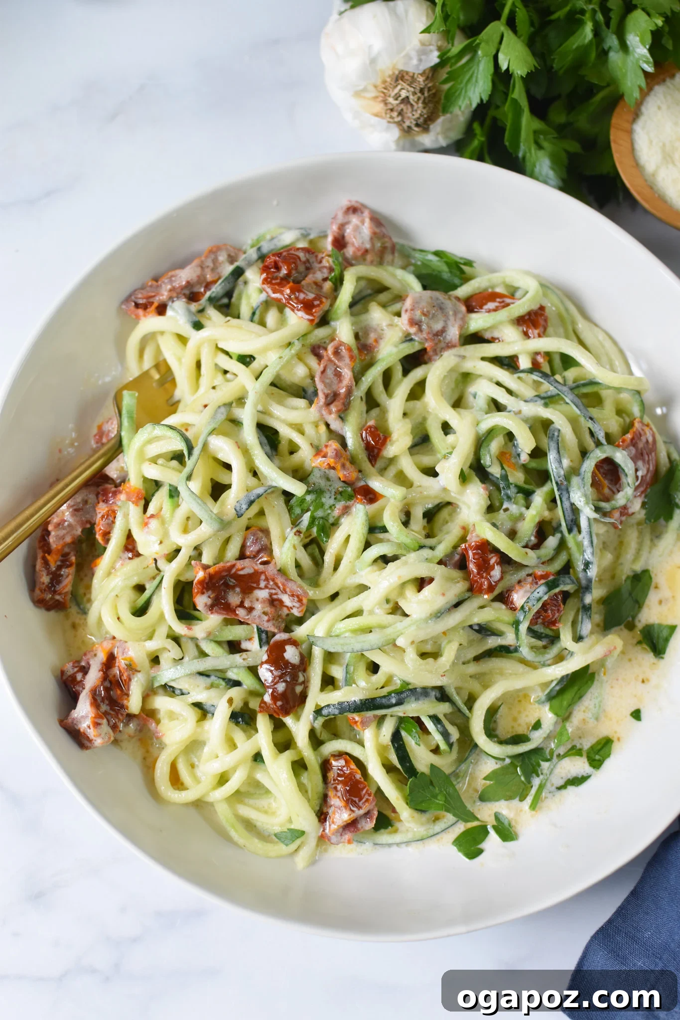 Creamy Zucchini Noodle Alfredo 4 Alfredo Zoodles Recipe in a white bowl, garnished with fresh herbs.