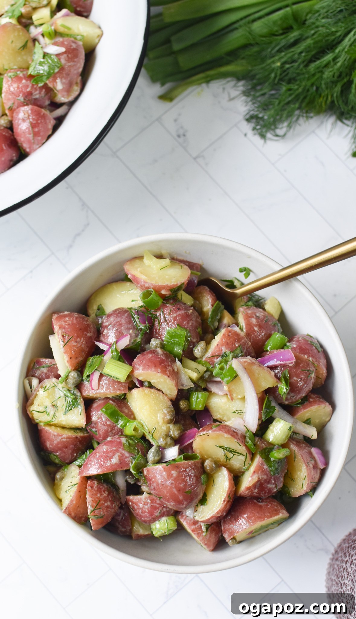 Bright and Tangy Potato Salad 7 No Mayo Potato Salad served in a white bowl with a gold spoon, ready to be enjoyed.