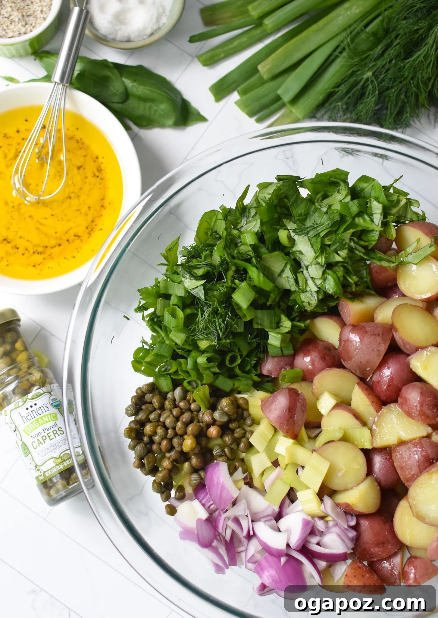 Bright and Tangy Potato Salad 9 No Mayo Potato Salad in a mixing bowl with a spoon, showing the combined ingredients.