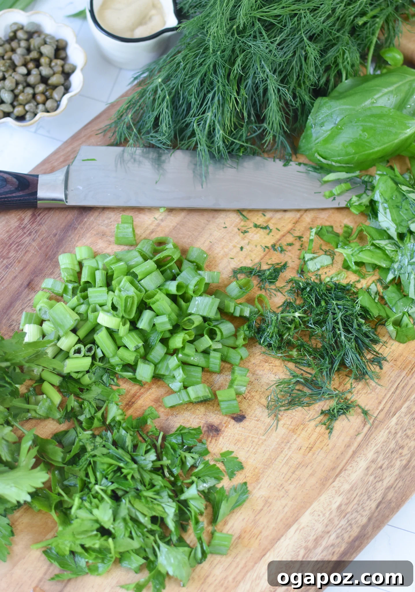 Bright and Tangy Potato Salad 10 Fresh herbs for No Mayo Potato Salad on a cutting board, including parsley, basil, and dill.
