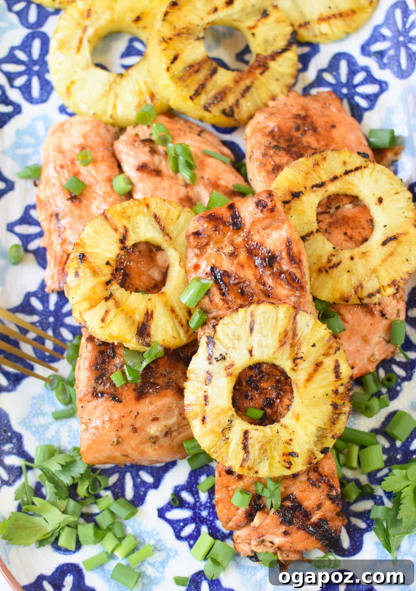 Aloha Grilled Salmon 2 Hawaiian Grilled Salmon on blue platter, garnished with fresh herbs and pineapple slices.