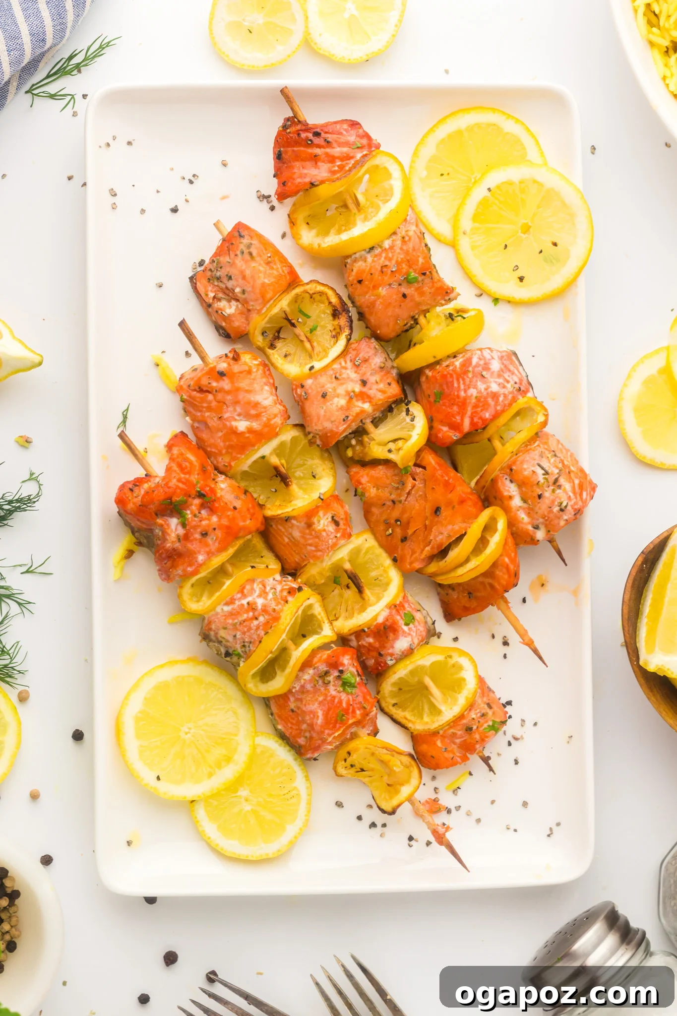 Quick Zesty Salmon Skewers 11 Easy Lemon Salmon Kabobs served on a white plate with a sprig of fresh herb.