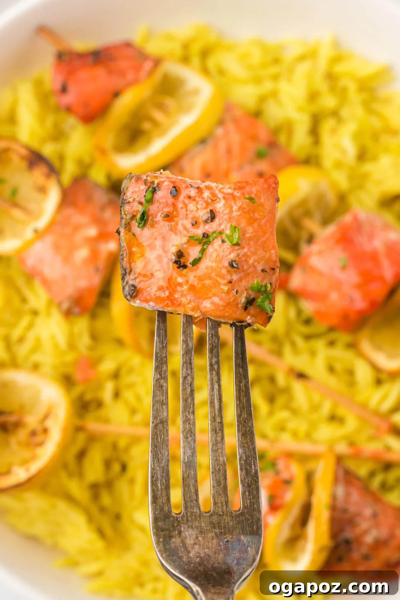 Quick Zesty Salmon Skewers 12 A close-up shot of a piece of cooked lemon salmon from a kabob on a fork, showing its tender, flaky texture.