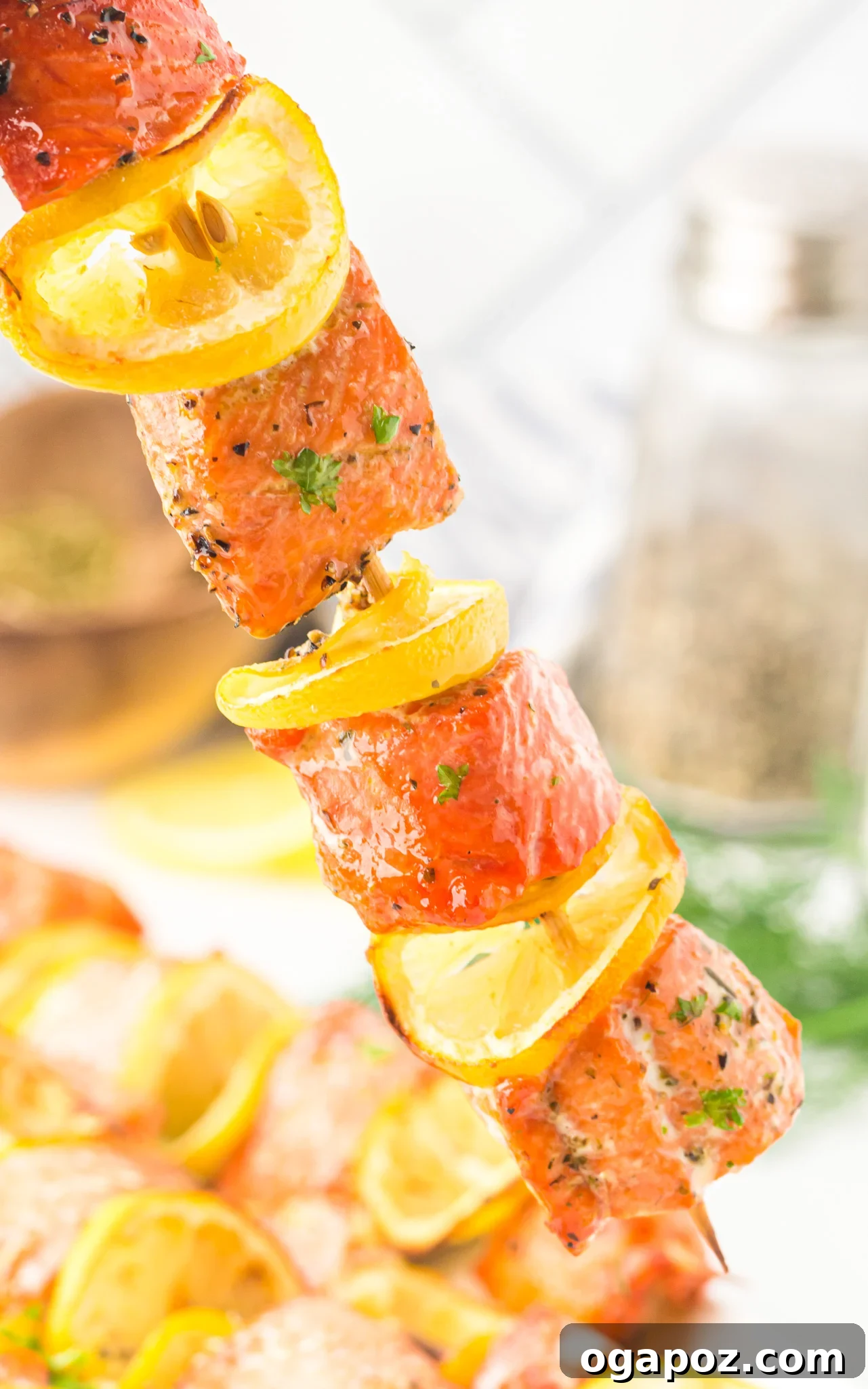 Quick Zesty Salmon Skewers 3 Two Easy Lemon Salmon Kabobs on a skewer, with fresh lemon wedges beside them, ready to be served.