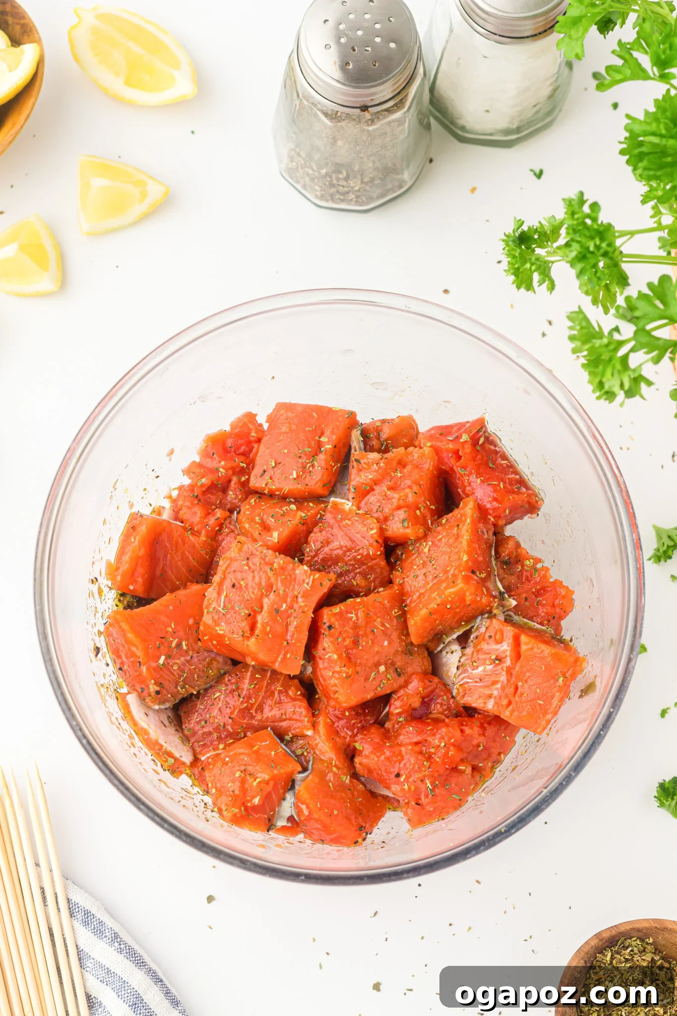 Quick Zesty Salmon Skewers 8 Fresh salmon cubes marinating in a bowl with lemon, garlic, and herbs.