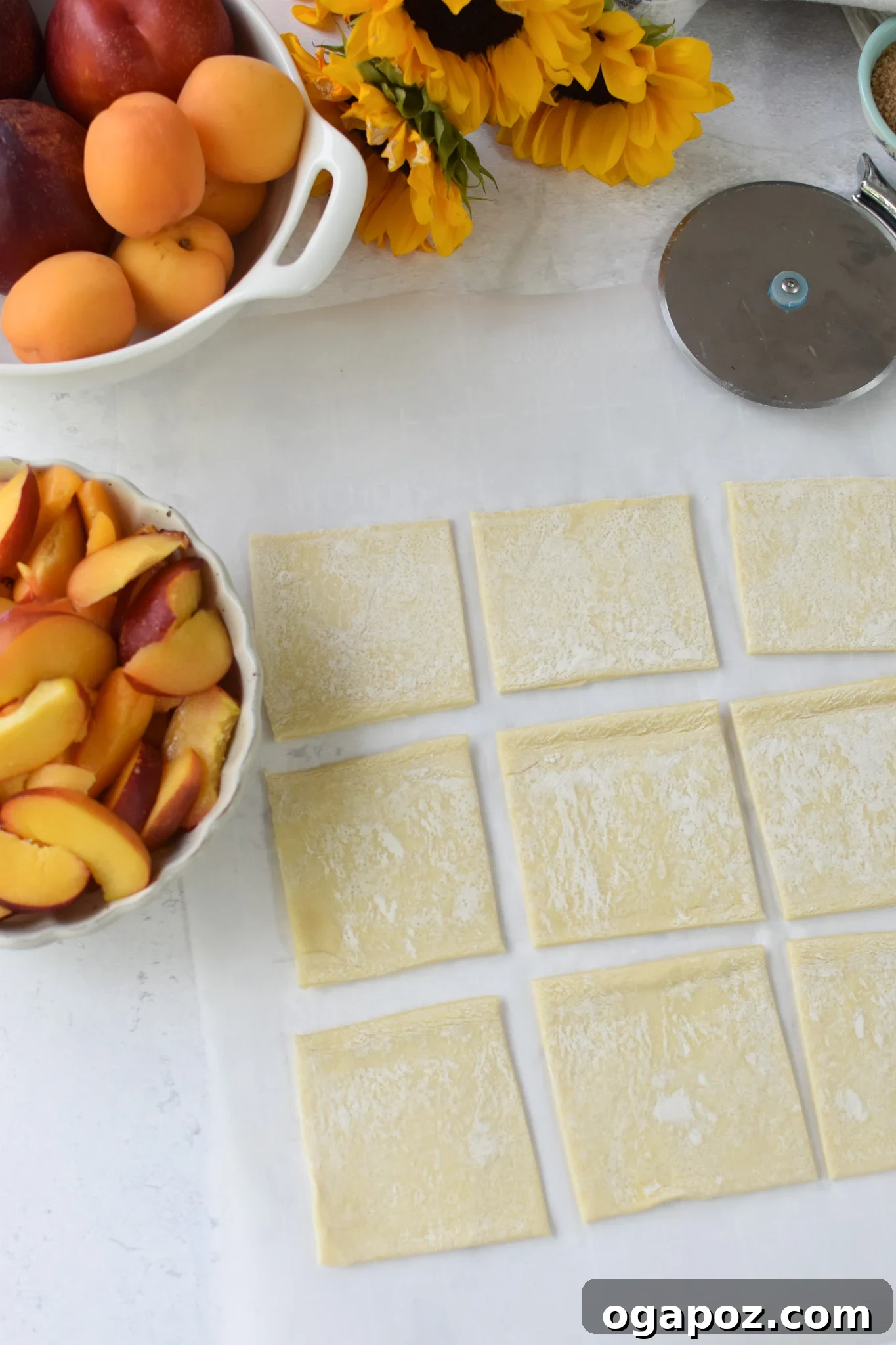 Effortless Golden Peach Tart 7 Neatly cut puff pastry squares arranged on a baking sheet, showcasing their ready-to-fill state. The pastry is light and uniform.