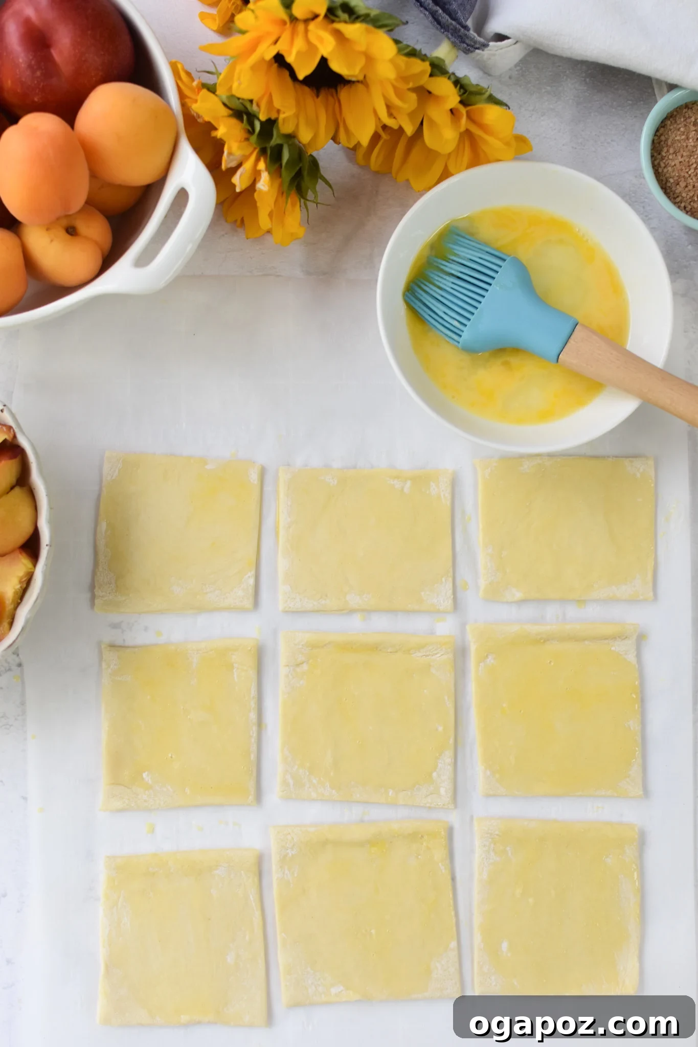 Effortless Golden Peach Tart 8 Puff pastry squares on a baking sheet, lightly brushed with egg wash, creating a subtle sheen before baking. This step is key for a golden finish.
